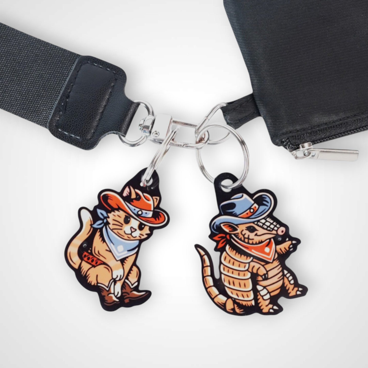Cowboy armadillo cast acrylic keychain with double coil keyring. Shown on wallet next to cowboy cat keychain.