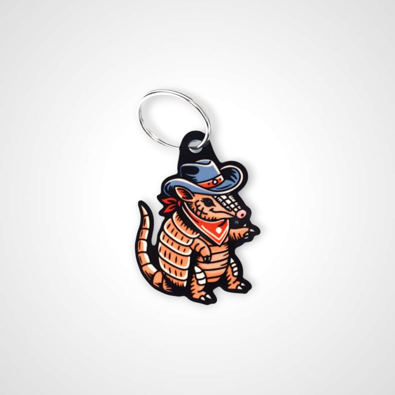 Cowboy armadillo cast acrylic keychain with double coil keyring. Shown on white background.