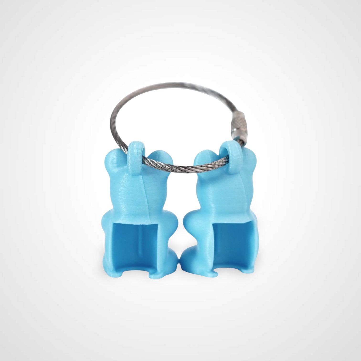 Two teal polylactic acid created using additive manufacturing gummy bear clips on steel cable keyring. Shown on a white background.