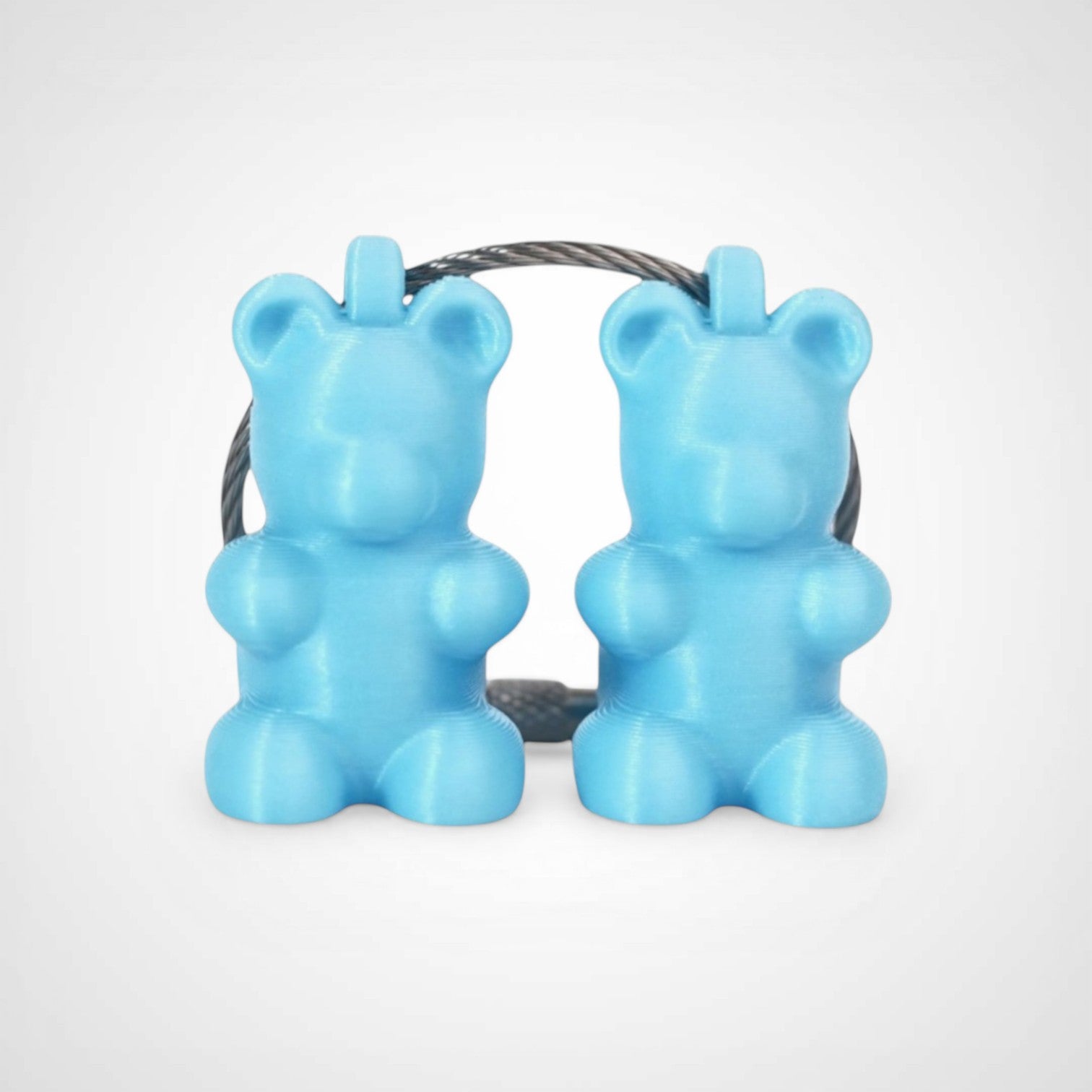 Two teal polylactic acid created using additive manufacturing gummy bear clips on steel cable keyring. Shown on a white background.