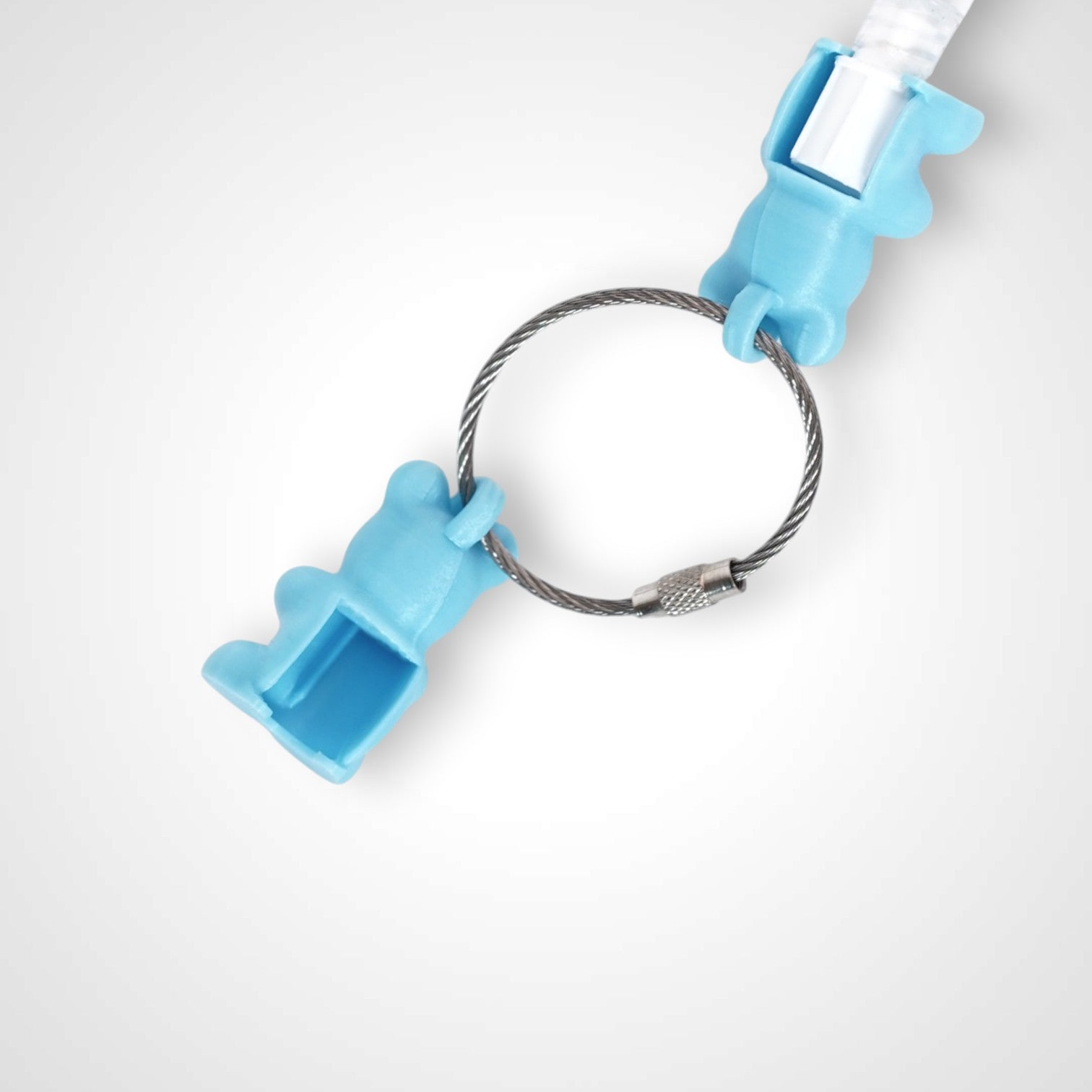Two teal polylactic acid created using additive manufacturing gummy bear clips on steel cable keyring. Featured attached to a syringe. Shown on a white background.