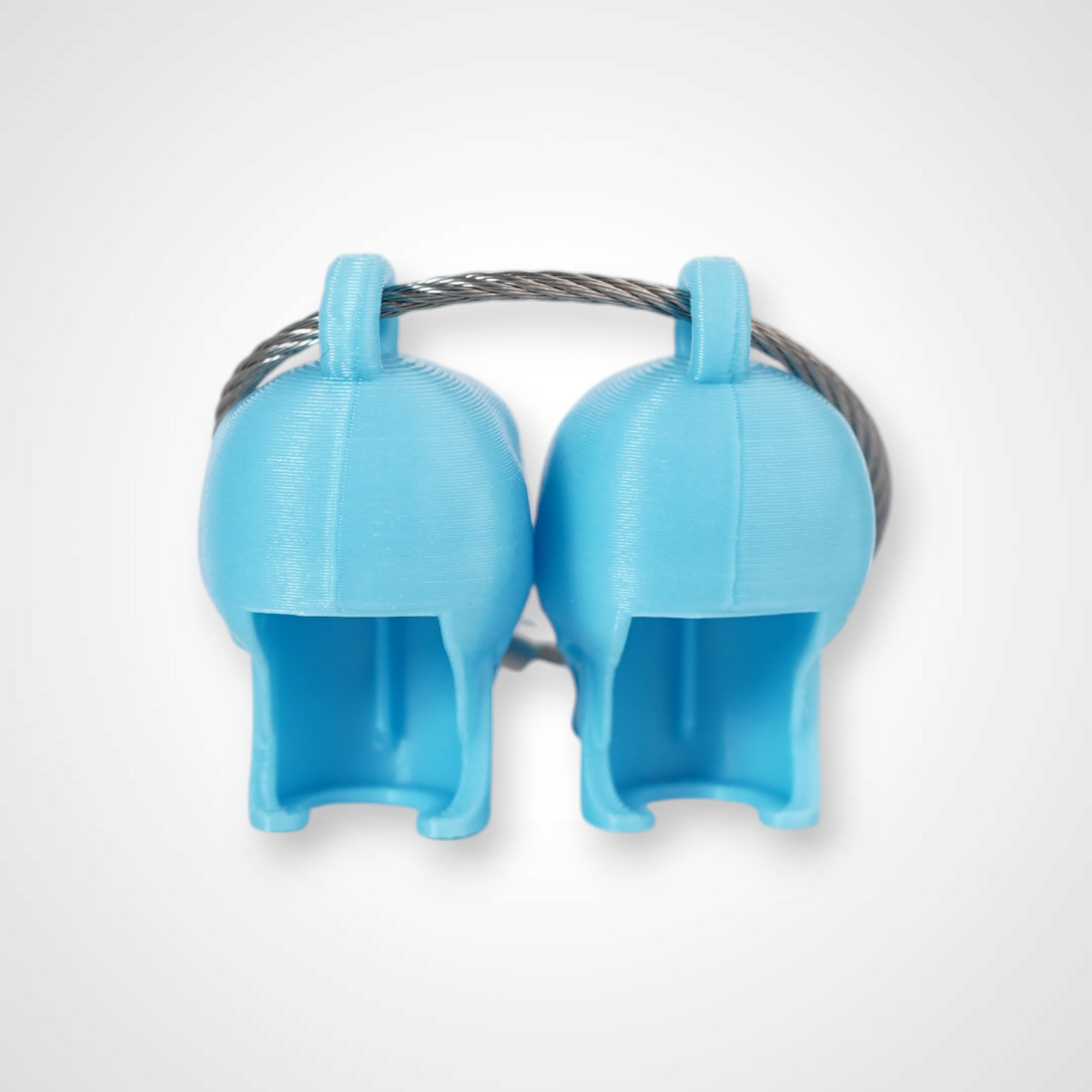 Two blue polylactic acid created using additive manufacturing skull cap clips on steel cable keyring. Shown on a white background.