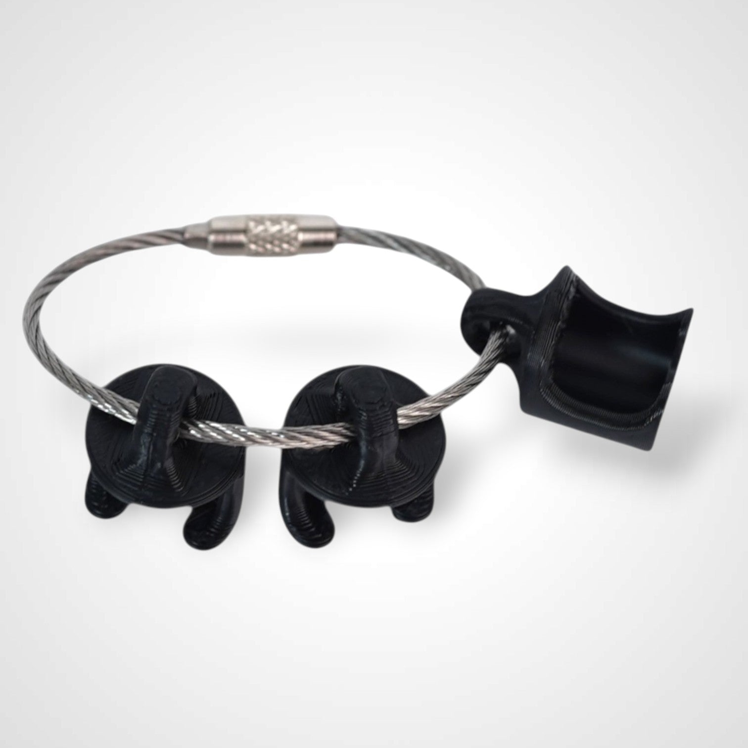 Black polylactic acid created using additive manufacturing B-Braun cap clip on steel cable keyring. Shown on white background.