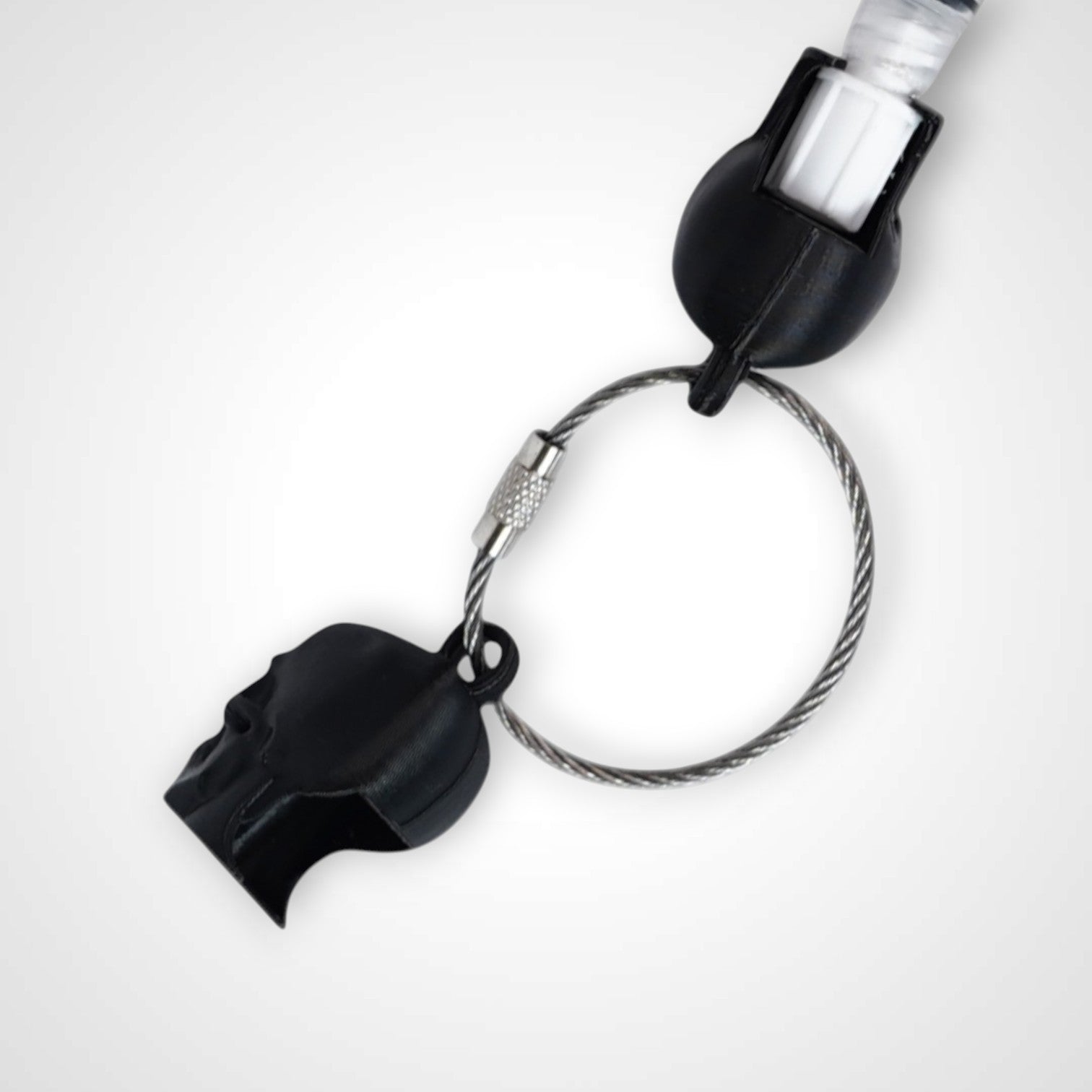 Two black polylactic acid created using additive manufacturing skull cap clips on steel cable keyring. Featured attached to a syringe. Shown on a white background.