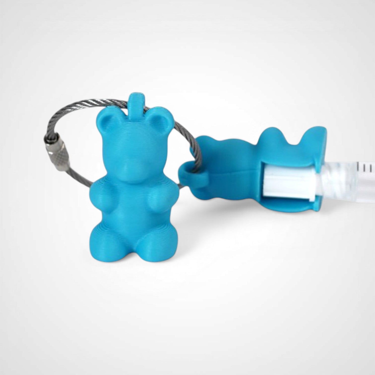 Two blue polylactic acid created using additive manufacturing gummy bear clips on steel cable keyring. Featured attached to a syringe. Shown on a white background.