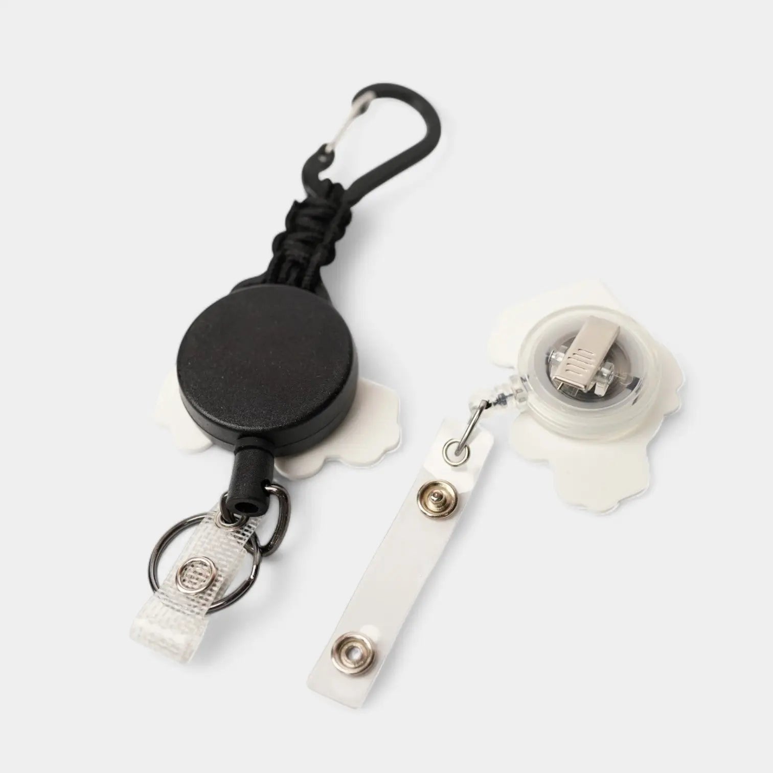 Taxi badge reel. On a carabiner with a steel retractable cable next to a swivel-alligator clip that rotates 360° with a nylon retractable string. Shown on a white background.