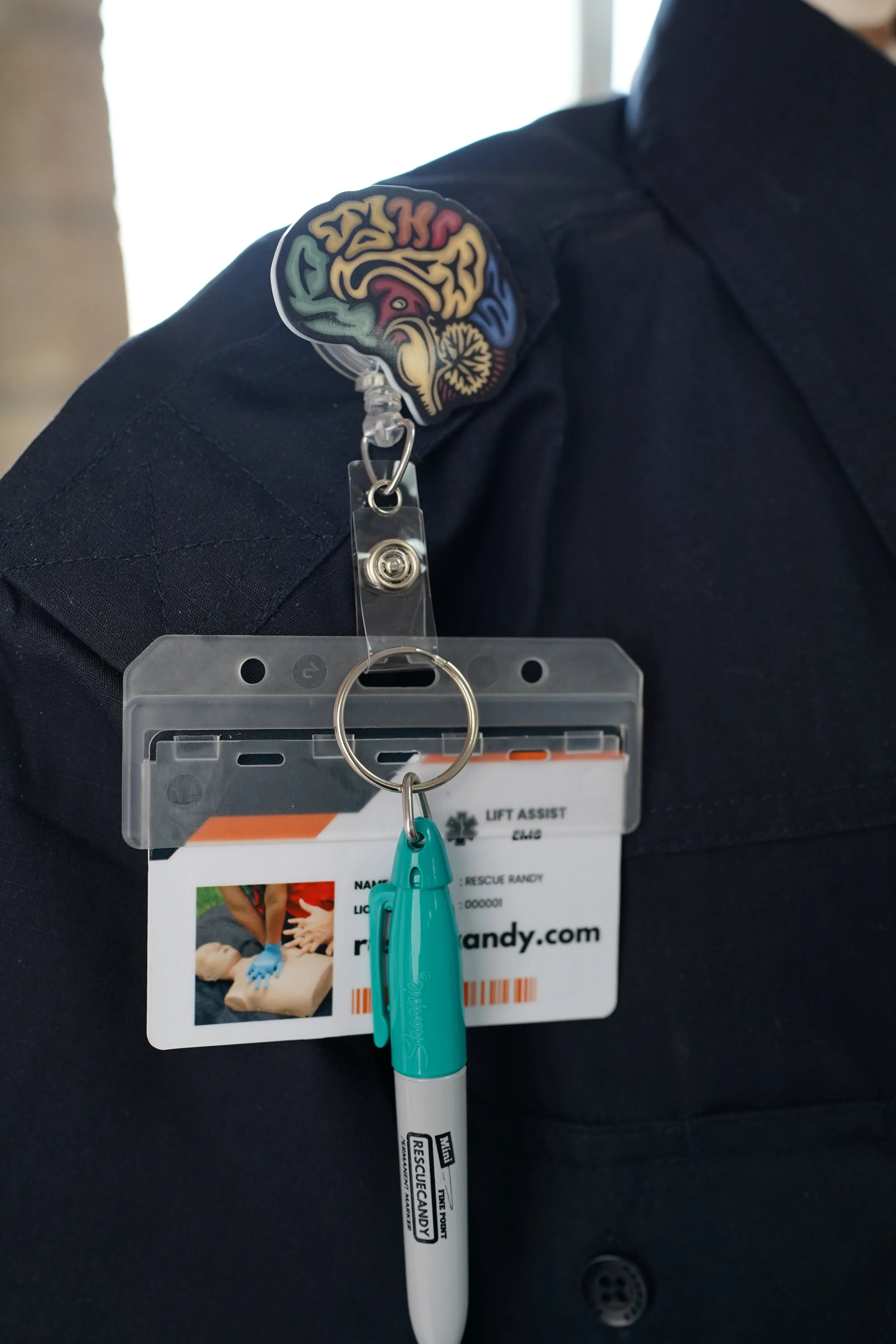 Sagittal Brain badge reel. On a swivel-alligator clip that rotates 360° with a nylon retractable string. Shown on a shirt.