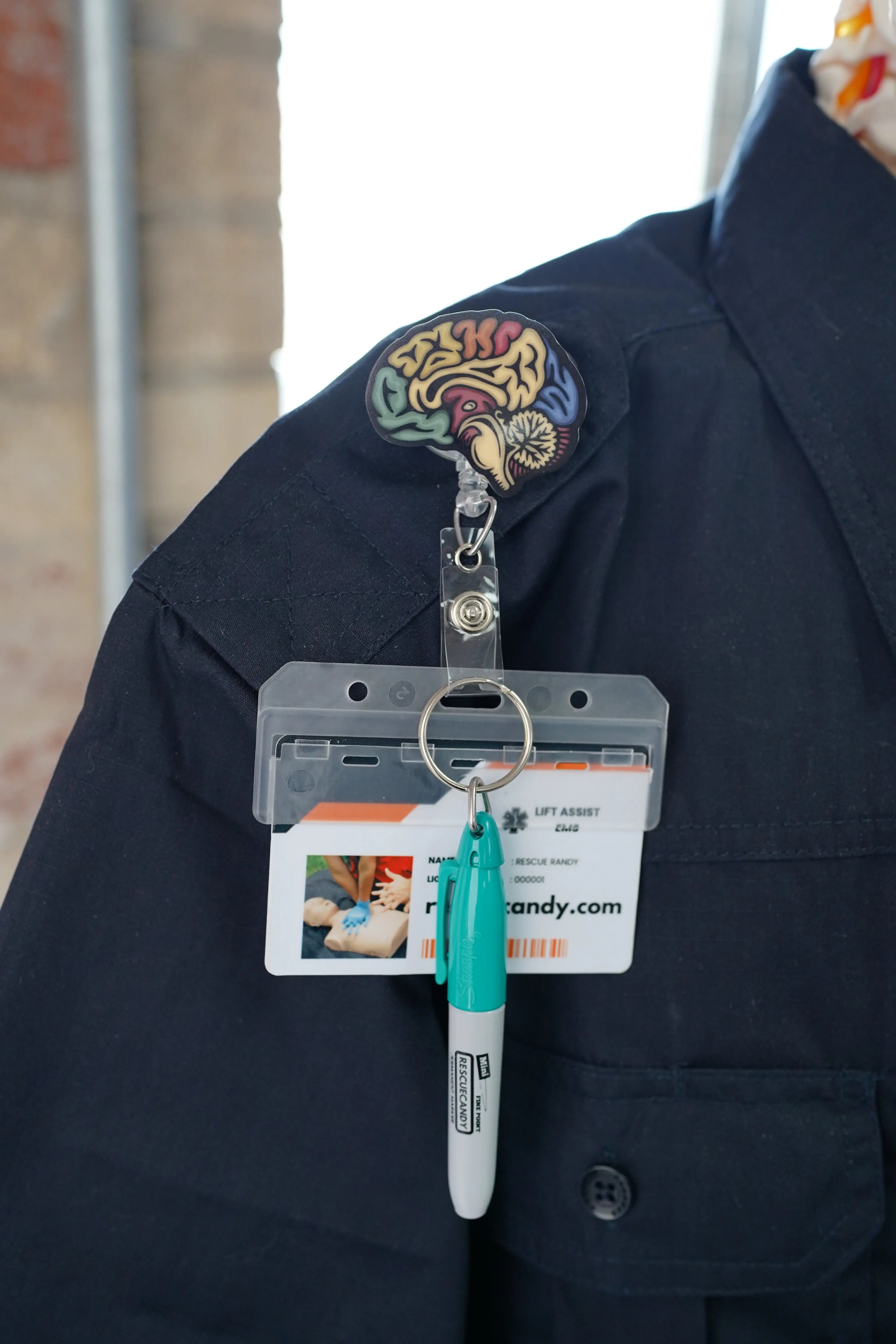 Sagittal Brain badge reel. On a swivel-alligator clip that rotates 360° with a nylon retractable string. Shown on a shirt.