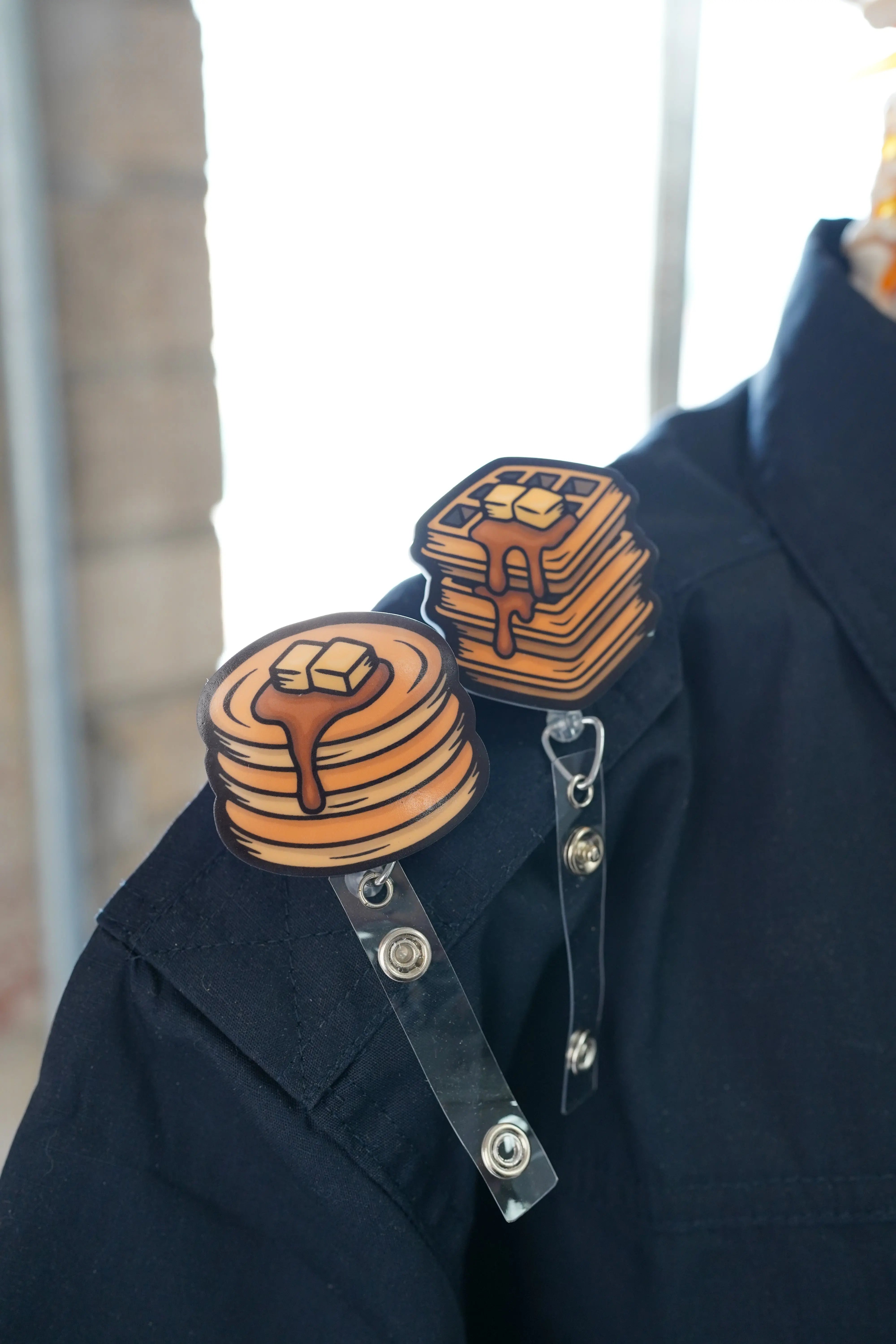 Pancake and waffle badge reel. On a swivel-alligator clip that rotates 360° with a nylon retractable string. Shown on a shirt.