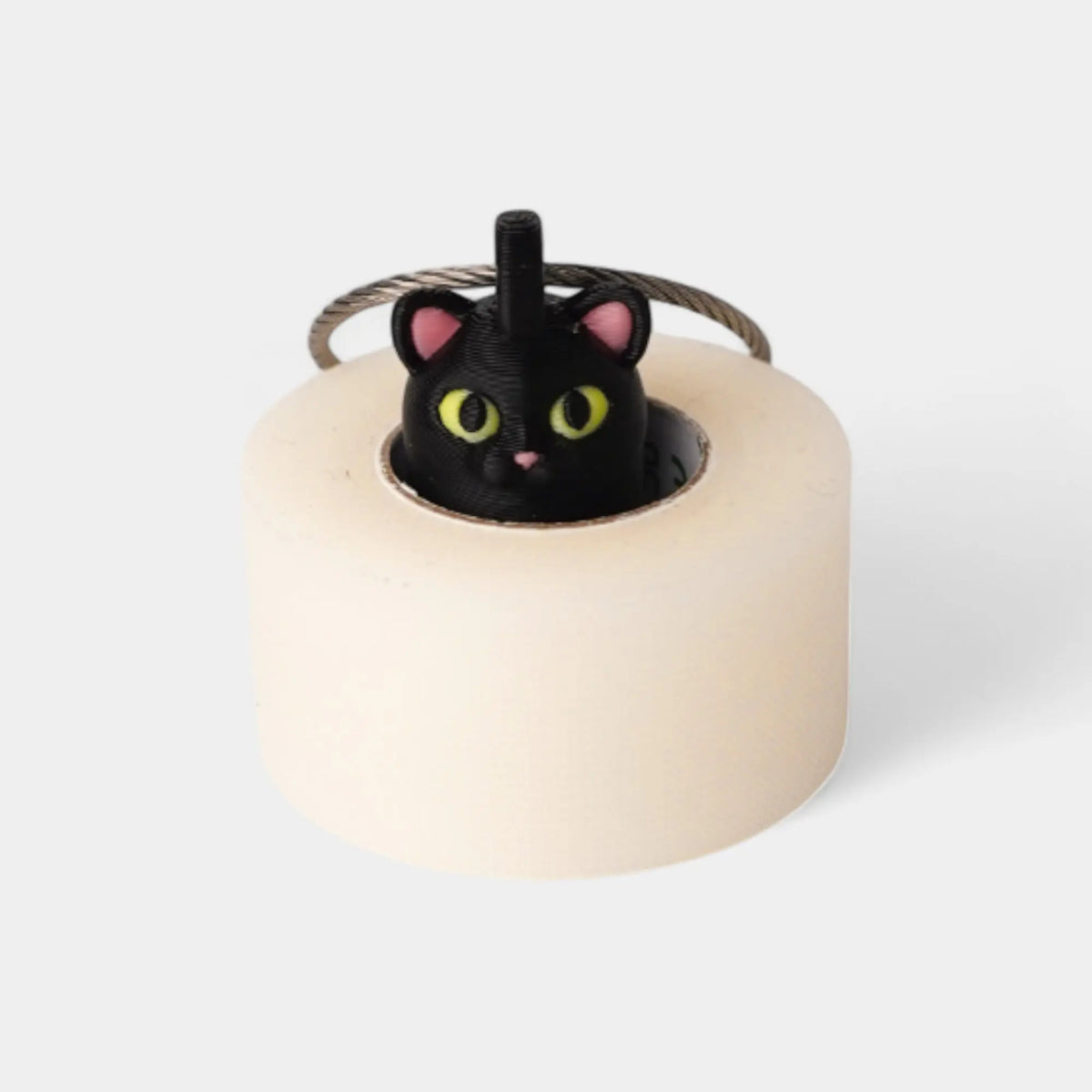 Halloween Cat Black 1-inch roll holder made with polylactic acid, created using additive manufacturing for holding tape and bandage rolls. With a steel cable keyring. Shown with tape on white background.