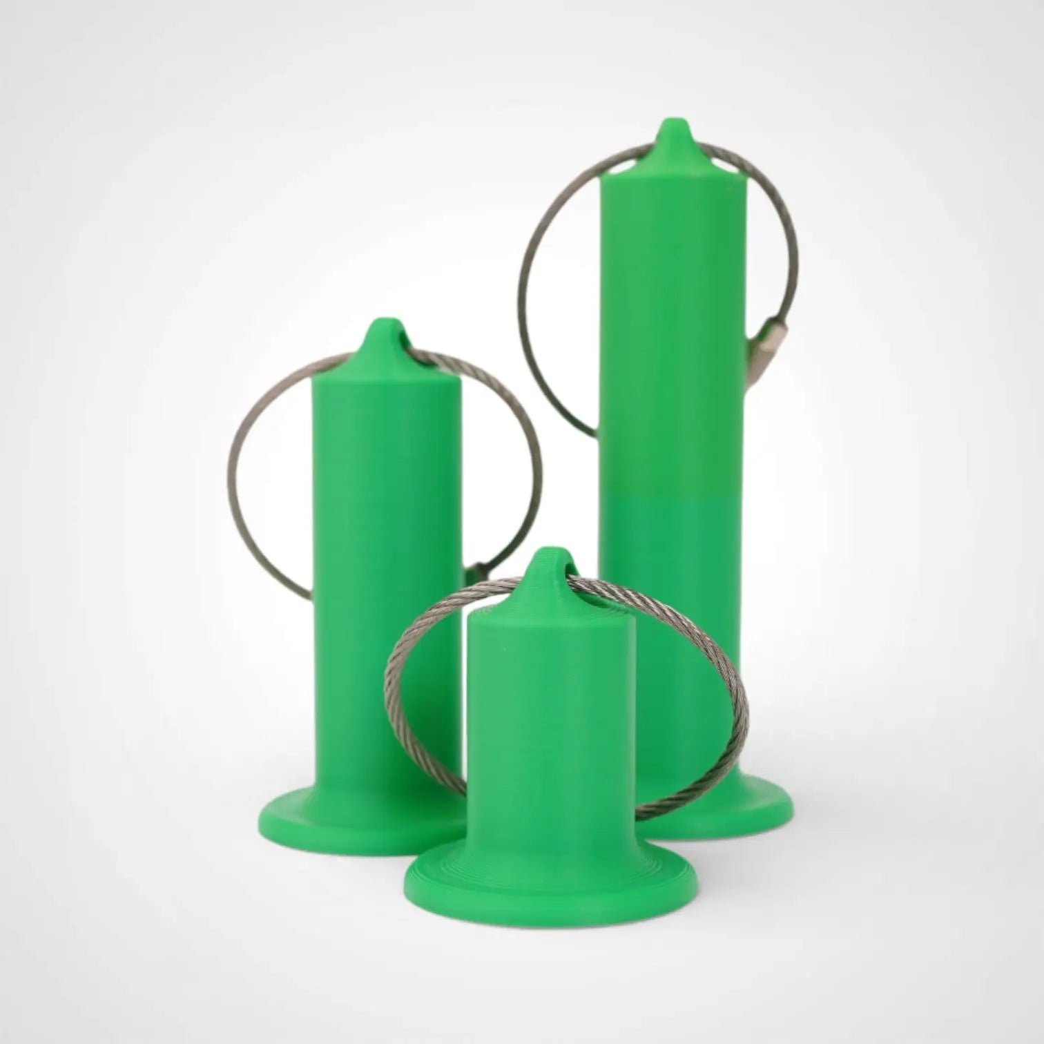 Green roll holders made with polylactic acid, created using additive manufacturing for holding tape and bandage rolls. In three sizes, 1-inch, 2-inch, and 3-inch. With a steel cable keyring. All three sizes shown on white background.