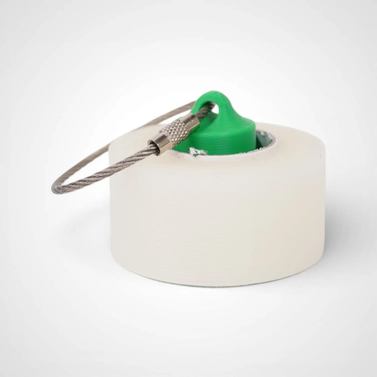 Green 1-inch roll holder made with polylactic acid, created using additive manufacturing for holding tape and bandage rolls. With a steel cable keyring. Shown with tape on white background.