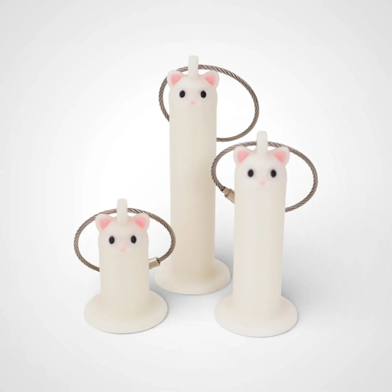 Cat White Glow roll holders made with polylactic acid, created using additive manufacturing for holding tape and bandage rolls. In three sizes, 1-inch, 2-inch, and 3-inch. With a steel cable keyring. All three sizes shown on white background.