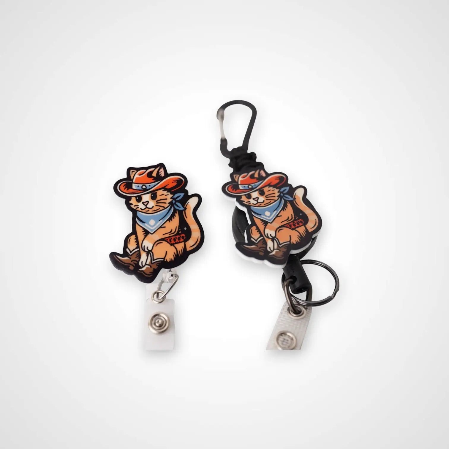 Cowboy Cat badge reel. On a carabiner with a steel retractable cable next to a swivel-alligator clip that rotates 360° with a nylon retractable string. Shown on a white background.