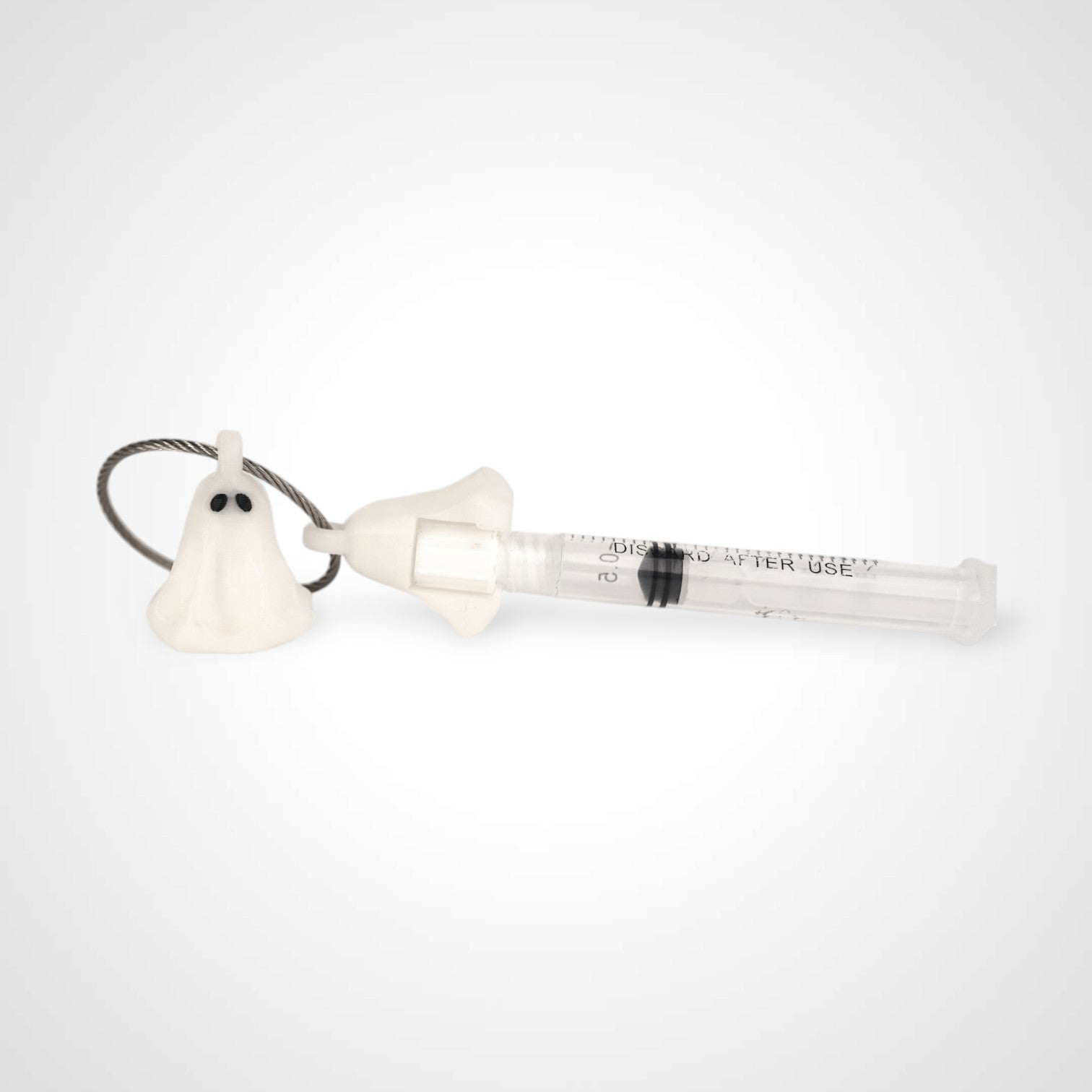 Two white polylactic acid created using additive manufacturing ghost cap clips on steel cable keyring. Featured attached to a syringe. Shown on a white background.