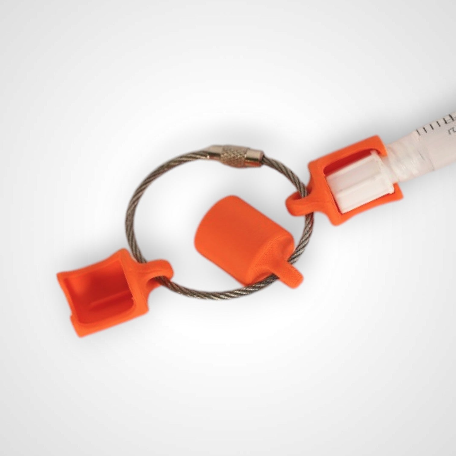 Three orange polylactic acid created using additive manufacturing classic cap clips on steel cable keyring. Featured attached to a syringe. Shown on a white background.