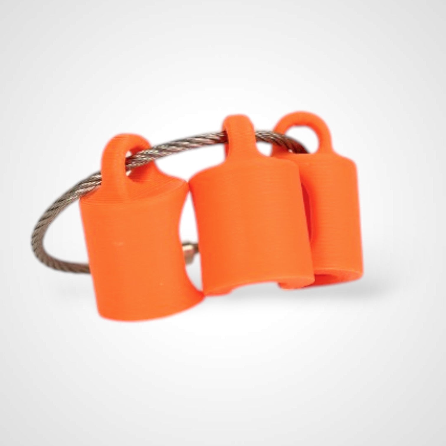 Three orange polylactic acid created using additive manufacturing classic cap clips on steel cable keyring. Shown on a white background.