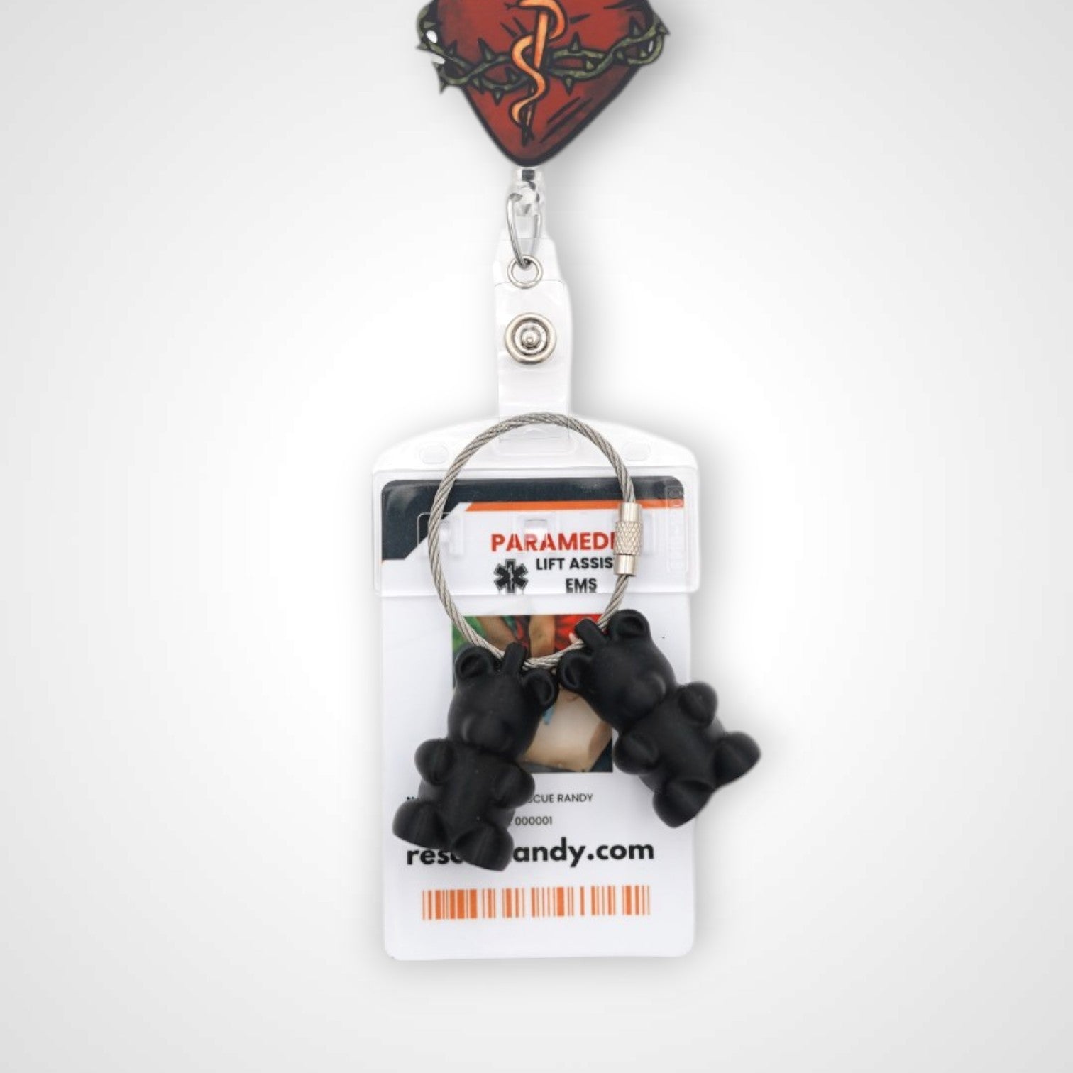 Two black polylactic acid created using additive manufacturing gummy bear cap clips on steel cable keyring. Featured attached to a badge. Shown on a white background.