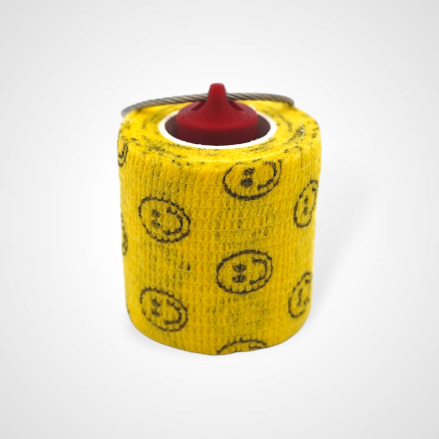 Red 2-inch roll holder made with polylactic acid, created using additive manufacturing for holding tape and bandage rolls. With a steel cable keyring. Shown with tape on white background.