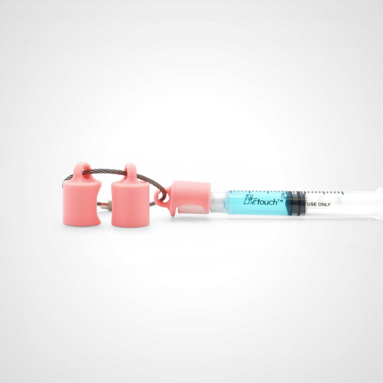 Three pink polylactic acid created using additive manufacturing classic cap clips on steel cable keyring. Featured attached to a syringe. Shown on a white background.