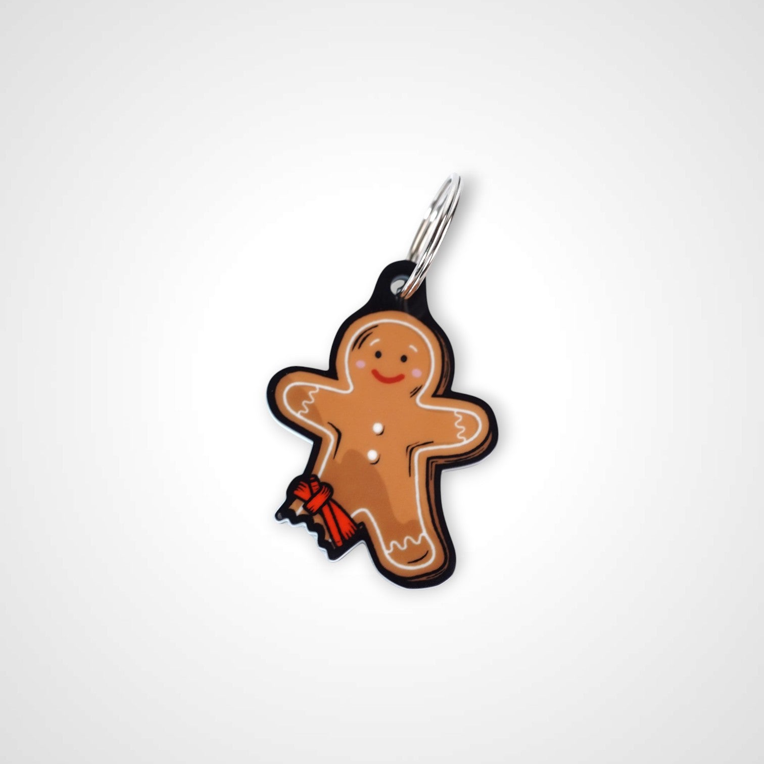 Tourniquet gingerbread man cast acrylic keychain with double coil keyring. Shown on white background.
