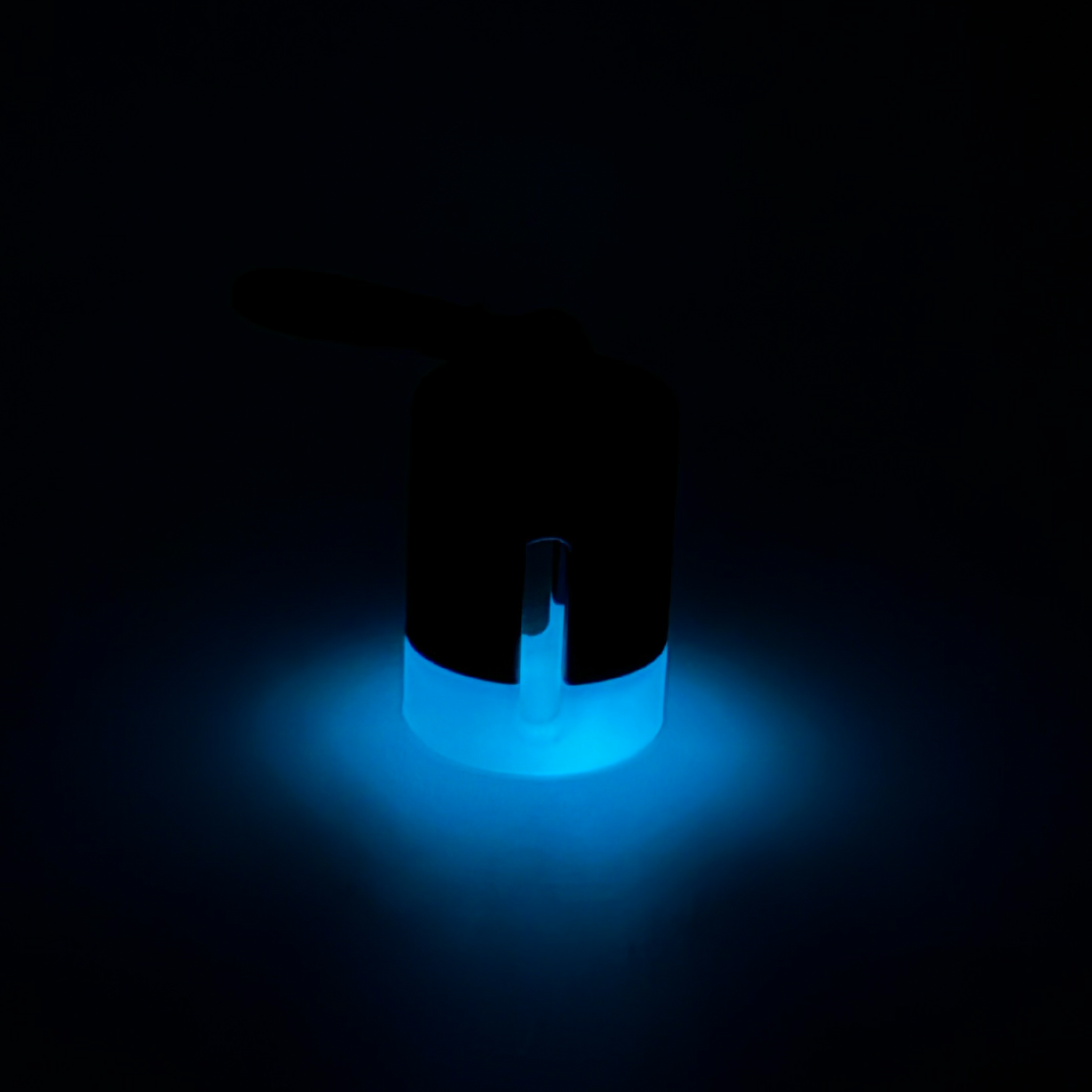Black with white stripe vial vault. For empty 2ml or smaller vials, made with polylactic acid created using additive manufacturing. With 1.37" stainless steel black coated carabiner. Shown glowing on black background.