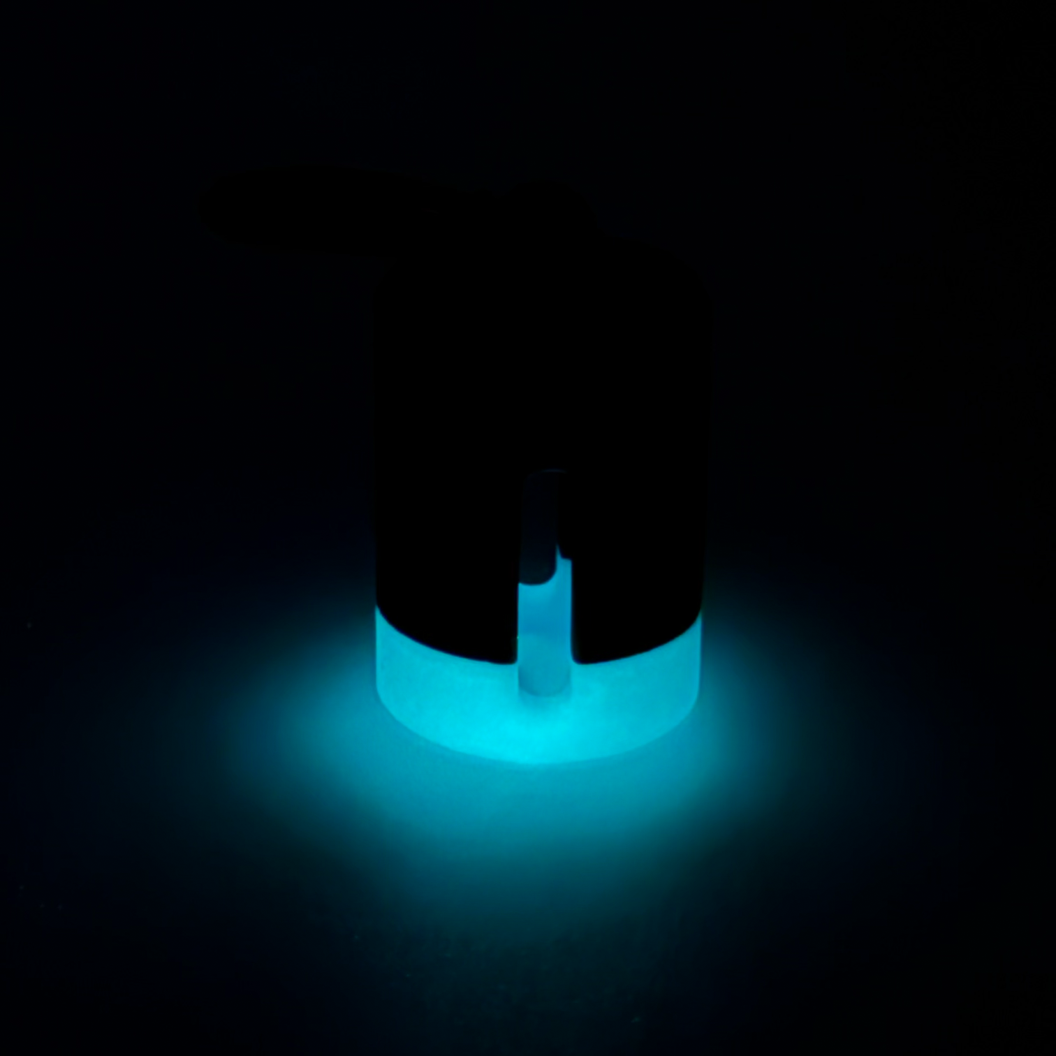 Black with blue stripe vial vault. For empty 2ml or smaller vials, made with polylactic acid created using additive manufacturing. With 1.37" stainless steel black coated carabiner. Shown glowing on black background.