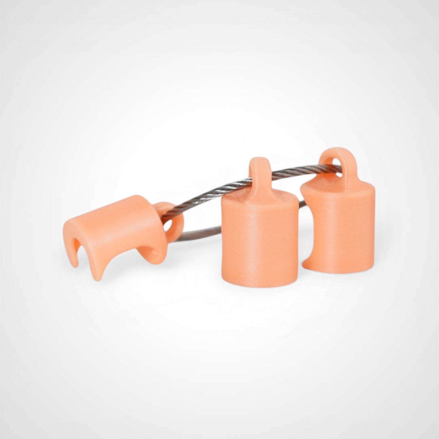 Three orange polylactic acid created using additive manufacturing classic cap clips on steel cable keyring. Shown on a white background.