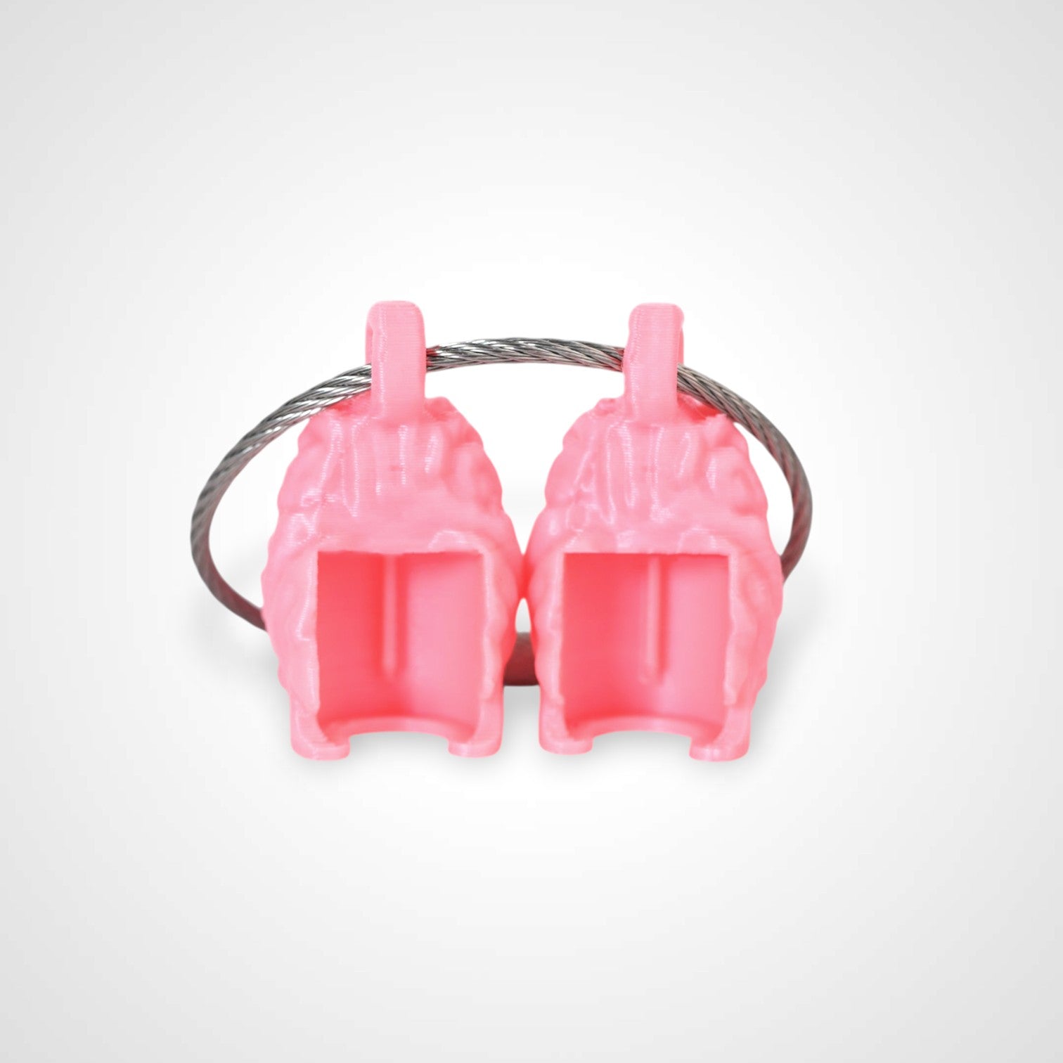 Two pink polylactic acid created using additive manufacturing anatomical brain cap clips on steel cable keyring. Shown on a white background.
