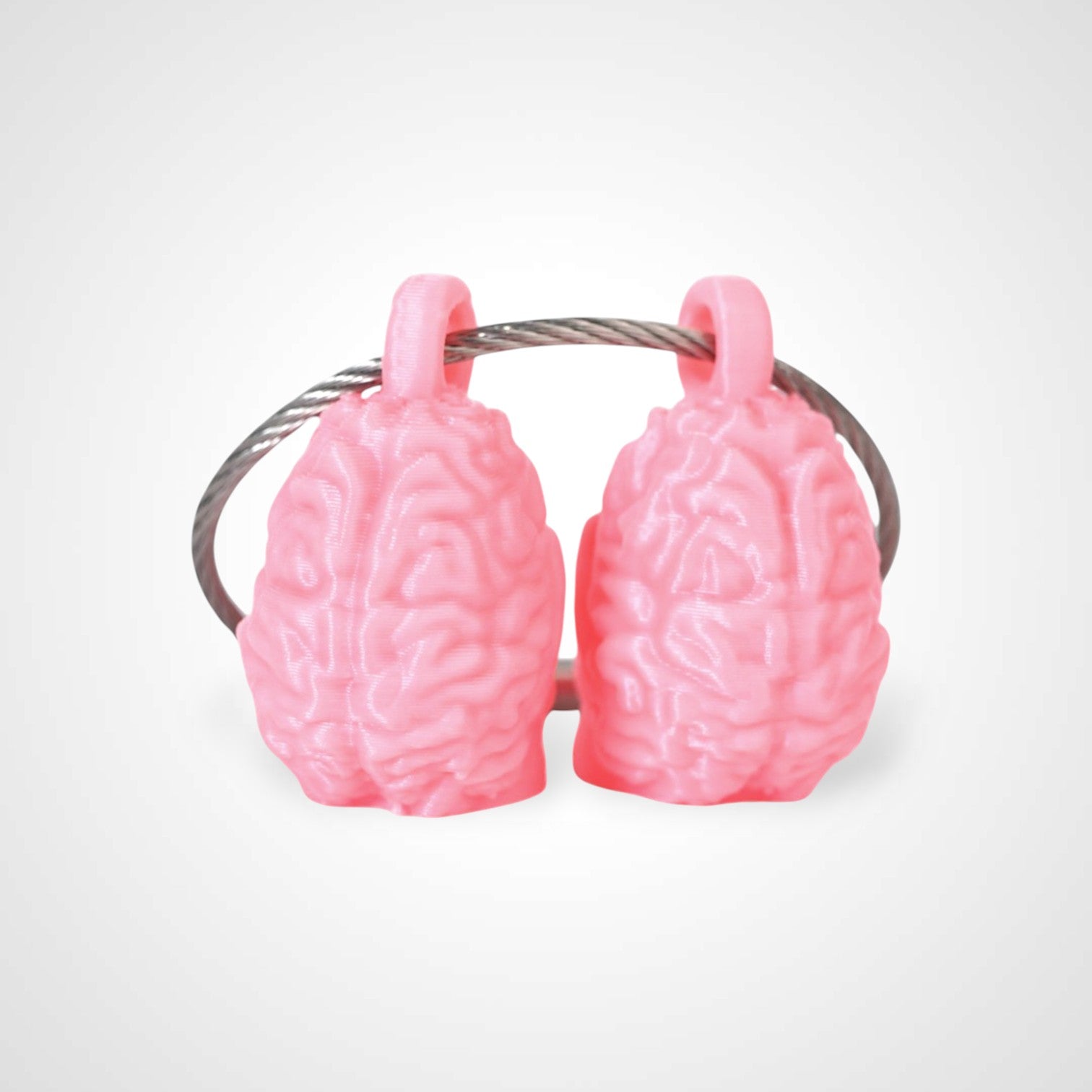 Two pink polylactic acid created using additive manufacturing anatomical brain cap clips on steel cable keyring. Shown on a white background.