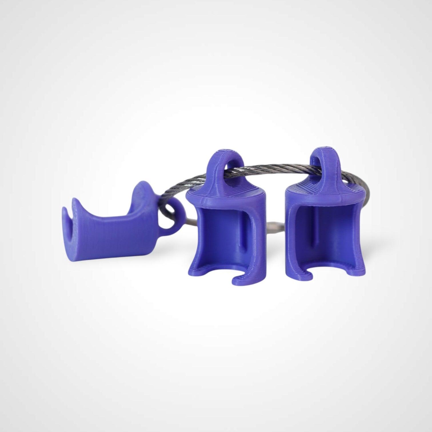 Three purple polylactic acid created using additive manufacturing classic cap clips on steel cable keyring. Shown on a white background.