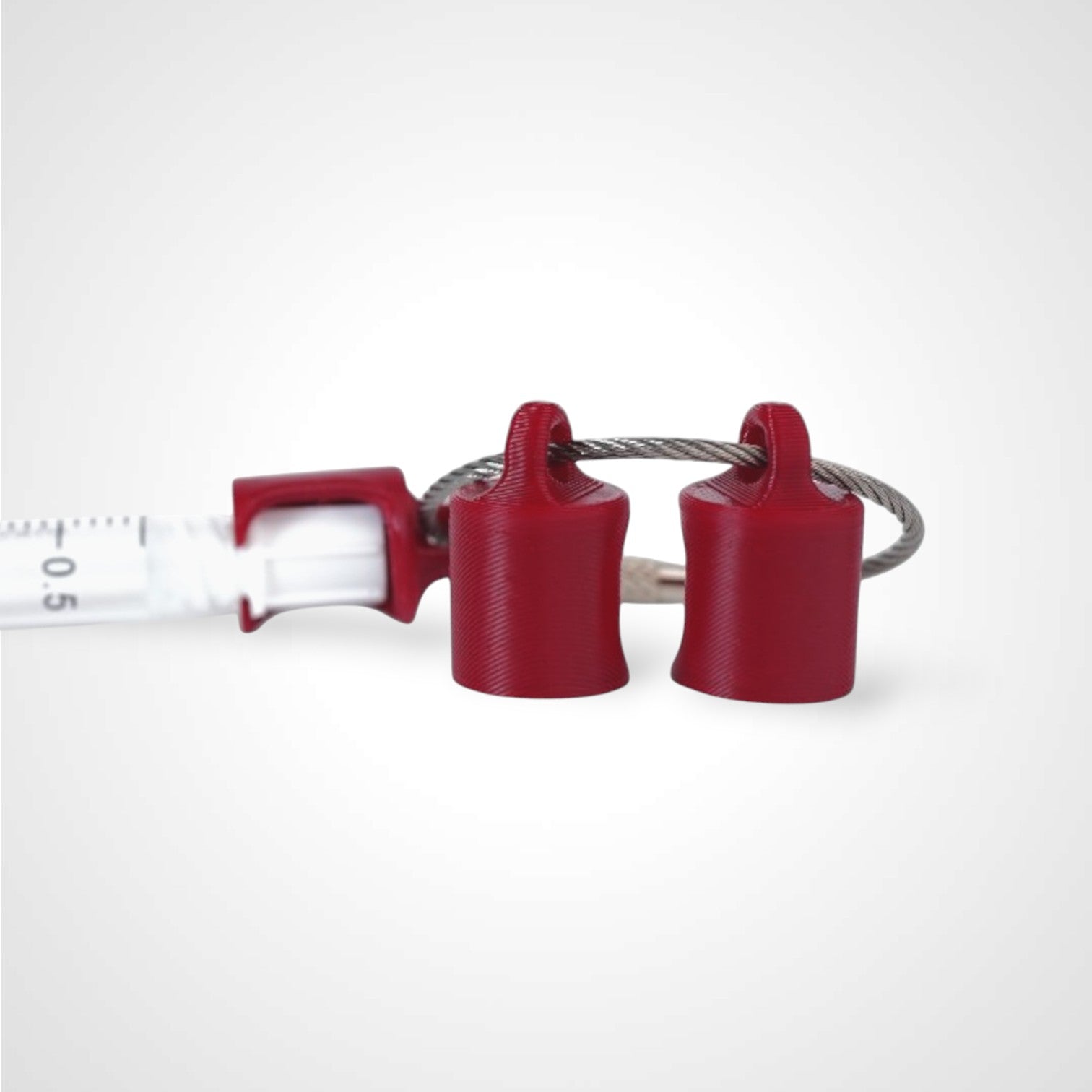 Three red polylactic acid created using additive manufacturing classic cap clip on steel cable keyring. Featured attached to syringe. Shown on white background.