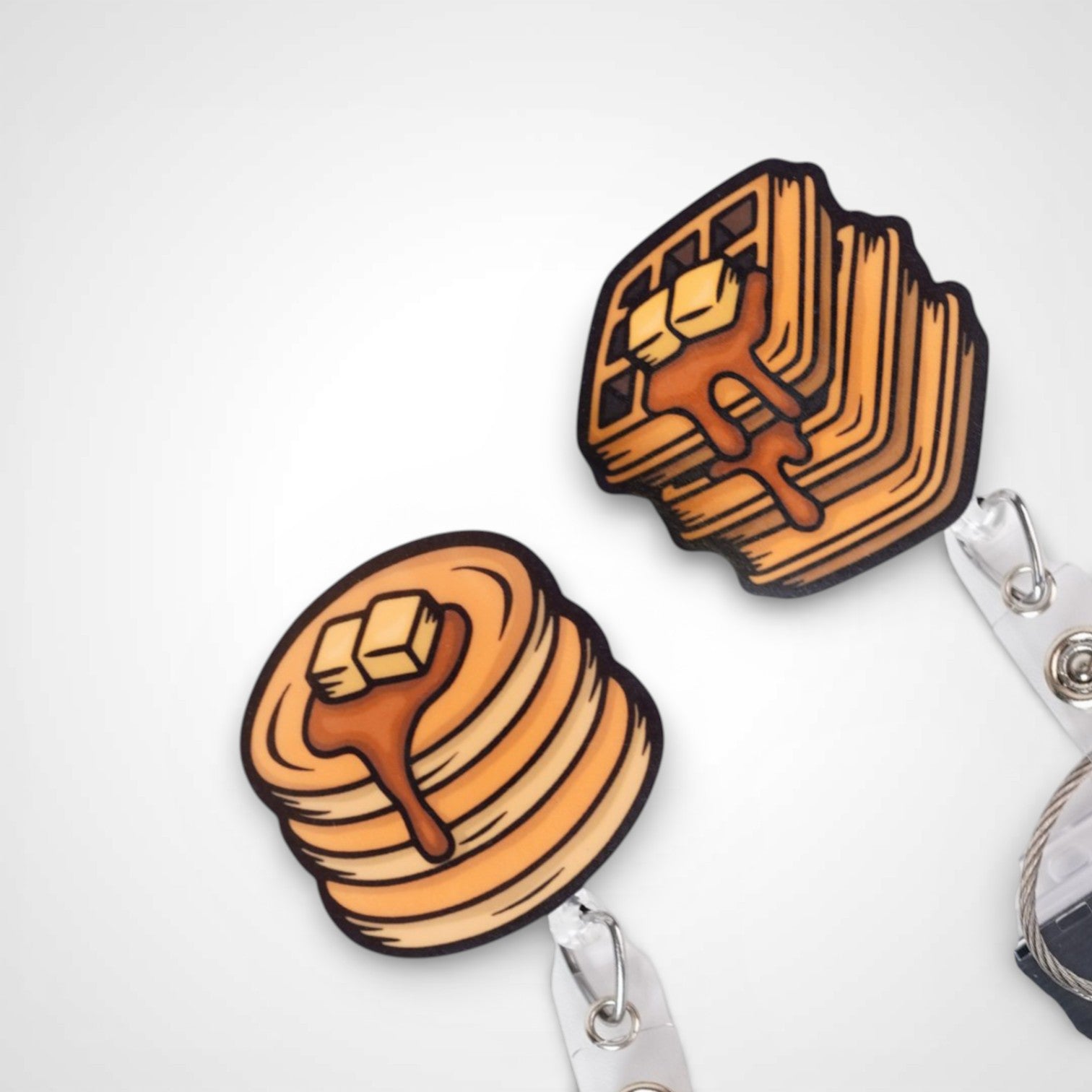 Pancake and waffle badge reel. On a swivel-alligator clip that rotates 360° with a nylon retractable string. Shown on a white background.