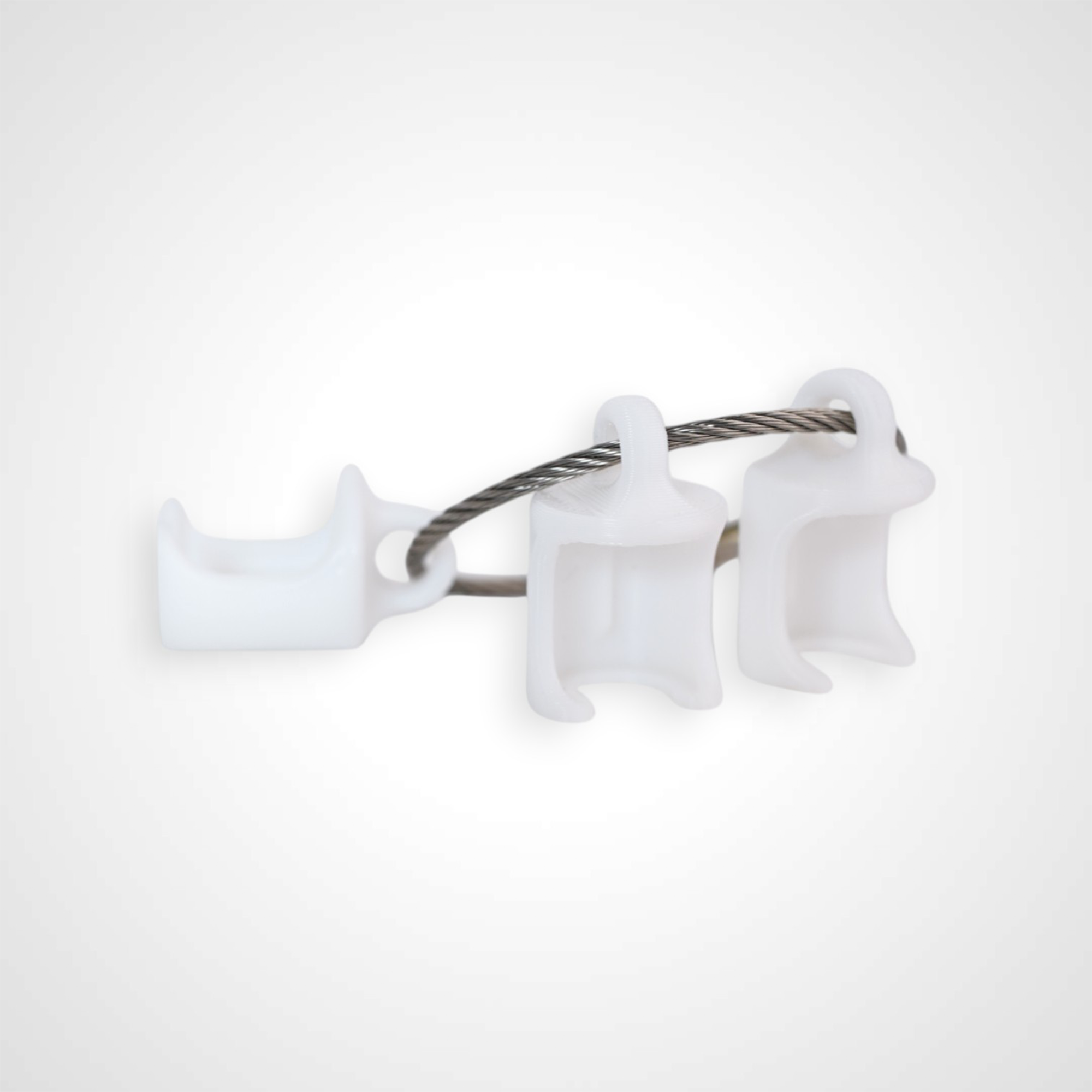 Three white polylactic acid created using additive manufacturing classic cap clips on steel cable keyring. Shown on a white background.