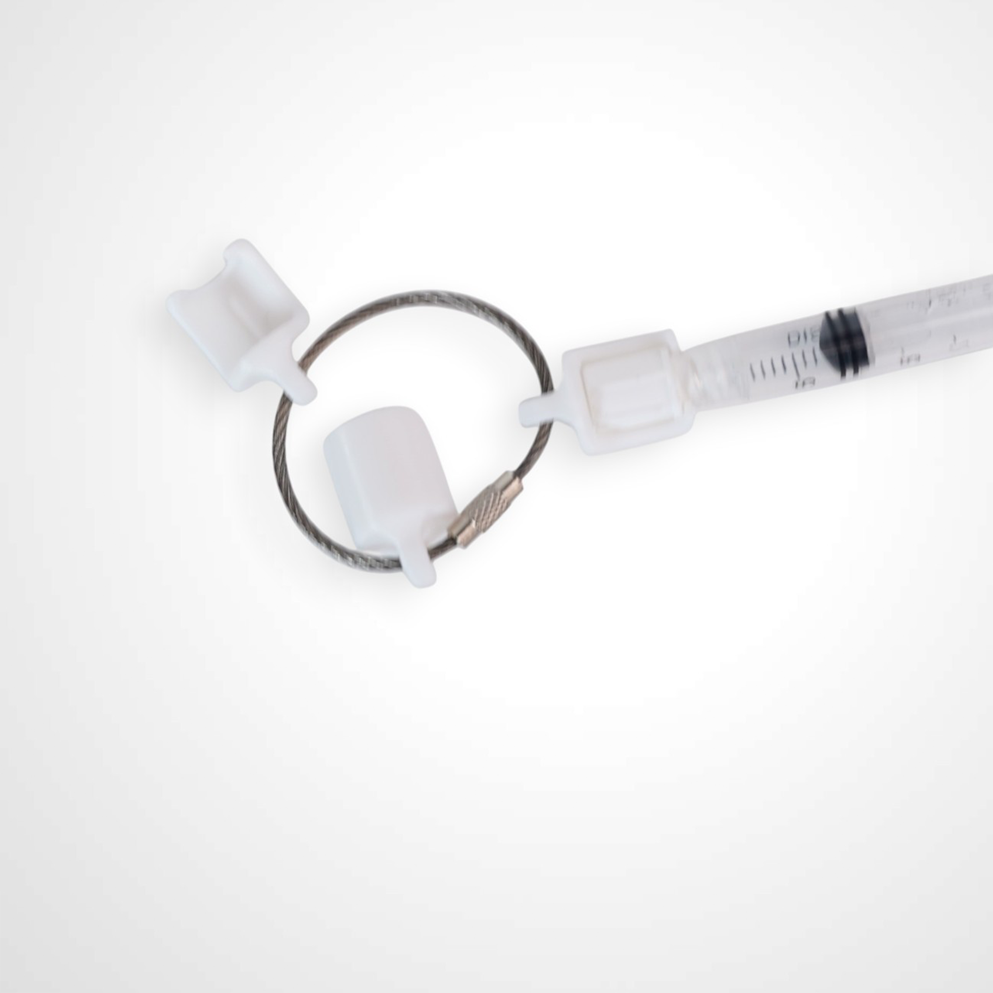 Three white polylactic acid created using additive manufacturing classic cap clips on steel cable keyring. Featured attached to a syringe. Shown on a white background.