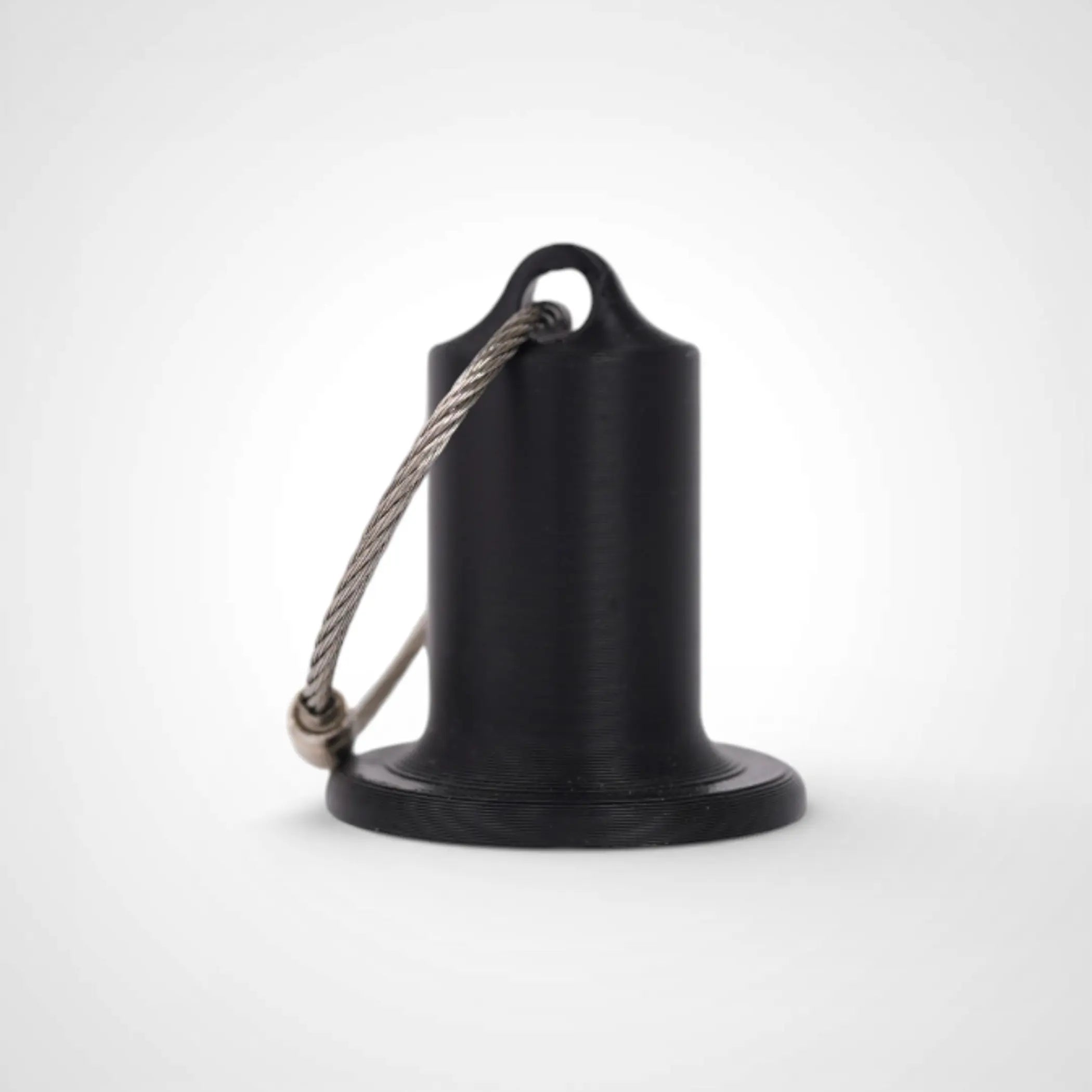 Black 1-inch roll holder made with polylactic acid, created using additive manufacturing for holding tape and bandage rolls. With a steel cable keyring. Shown on white background.