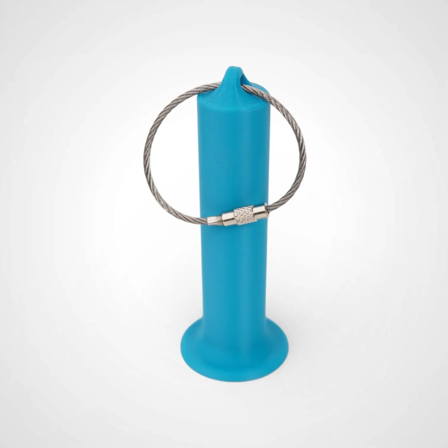 3-inch blue roll holder made with polylactic acid created using additive manufacturing for holding tape and bandage rolls. With a steel cable keyring. Shown on white background.
3-inch tall