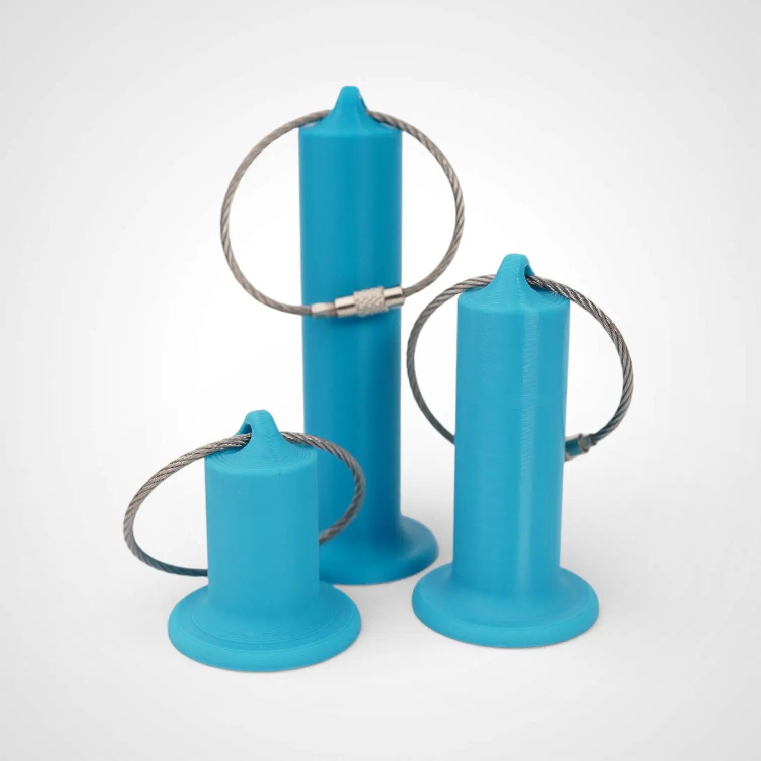 Blue roll holders made with polylactic acid created using additive manufacturing for holding tape and bandage rolls. In three sizes, 1 inch, 2 inch and 3 inch. With a steel cable keyring. All three sizes shown on white background.