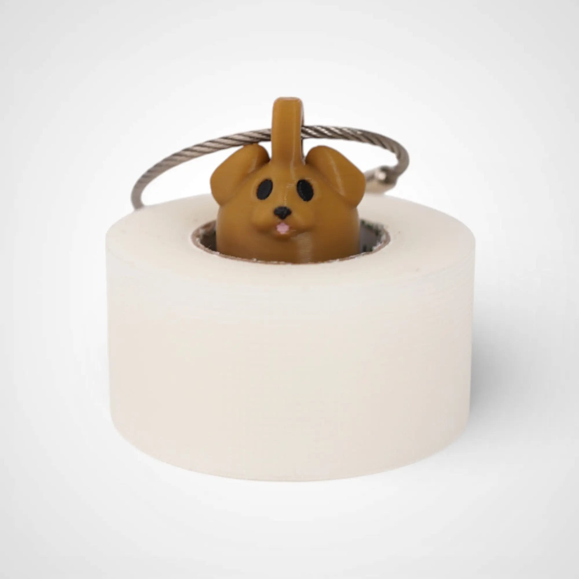 Brown Dog 1-inch roll holder made with polylactic acid, created using additive manufacturing for holding tape and bandage rolls. With a steel cable keyring. Shown with tape on white background.