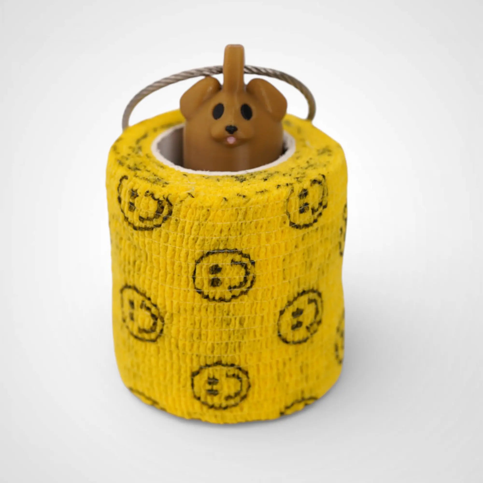 Brown Dog 2-inch roll holder made with polylactic acid, created using additive manufacturing for holding tape and bandage rolls. With a steel cable keyring. Shown with tape on white background.