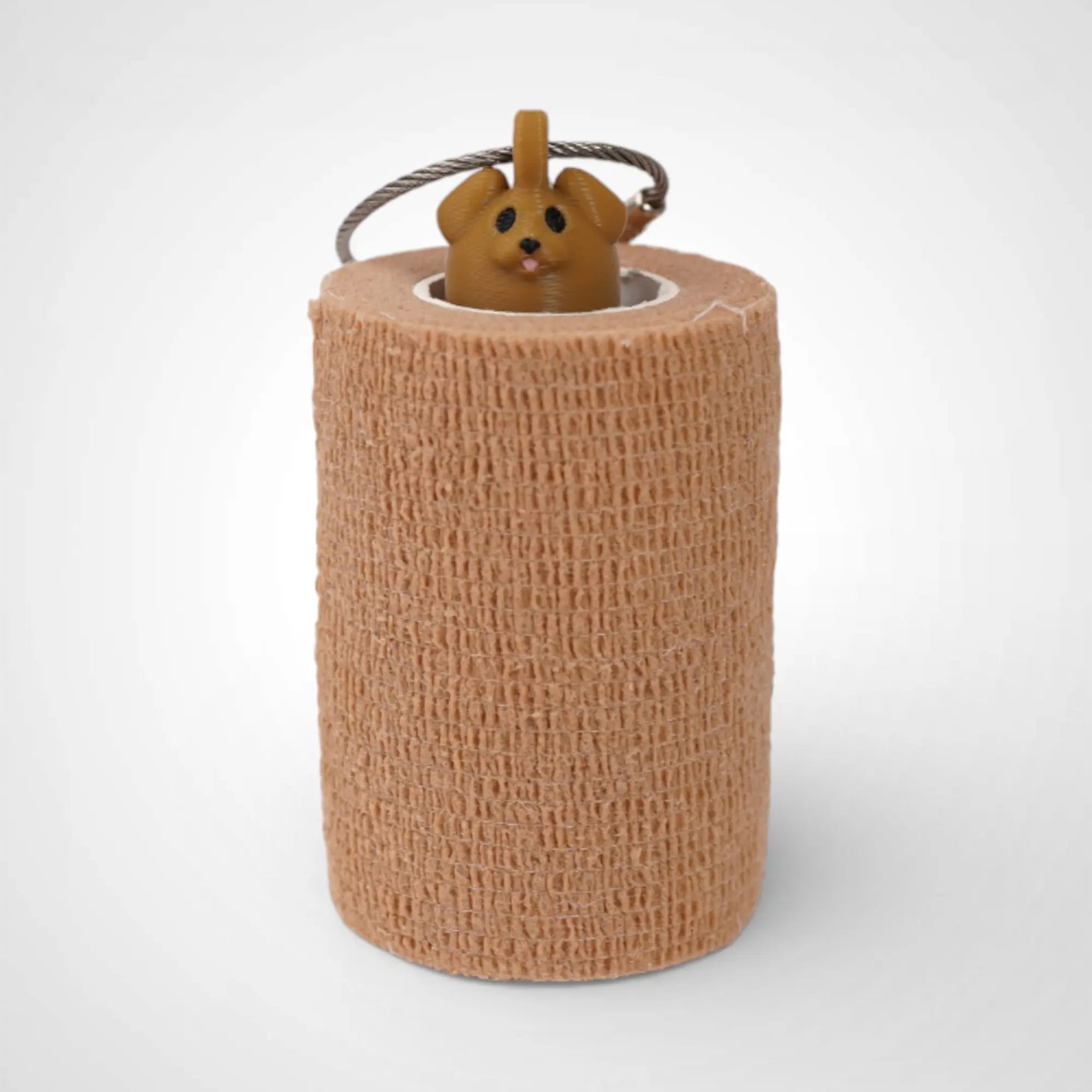 Brown Dog 3-inch roll holder made with polylactic acid, created using additive manufacturing for holding tape and bandage rolls. With a steel cable keyring. Shown with tape on white background.