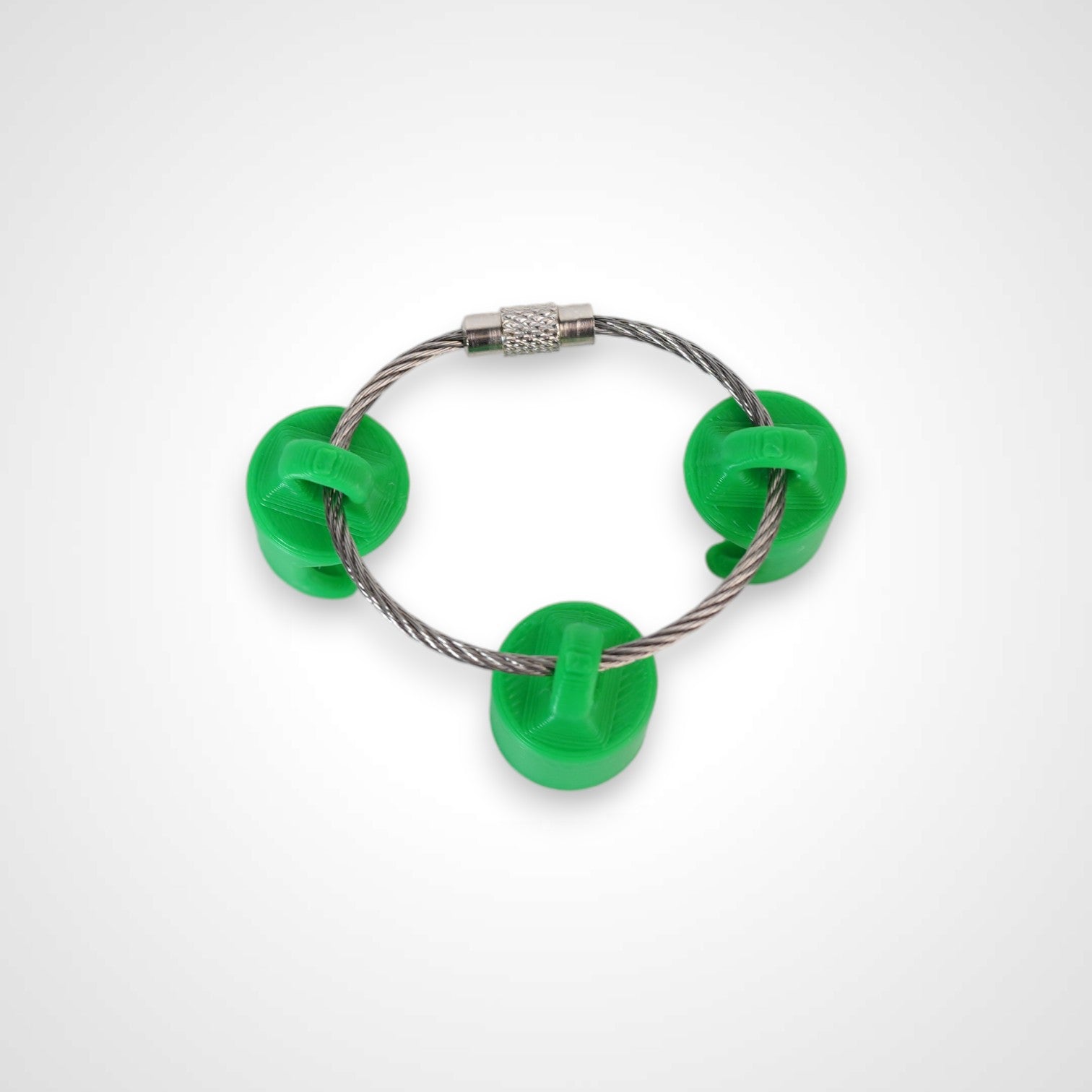 Three green polylactic acid created using additive manufacturing classic cap clips on steel cable keyring. Shown on a white background.