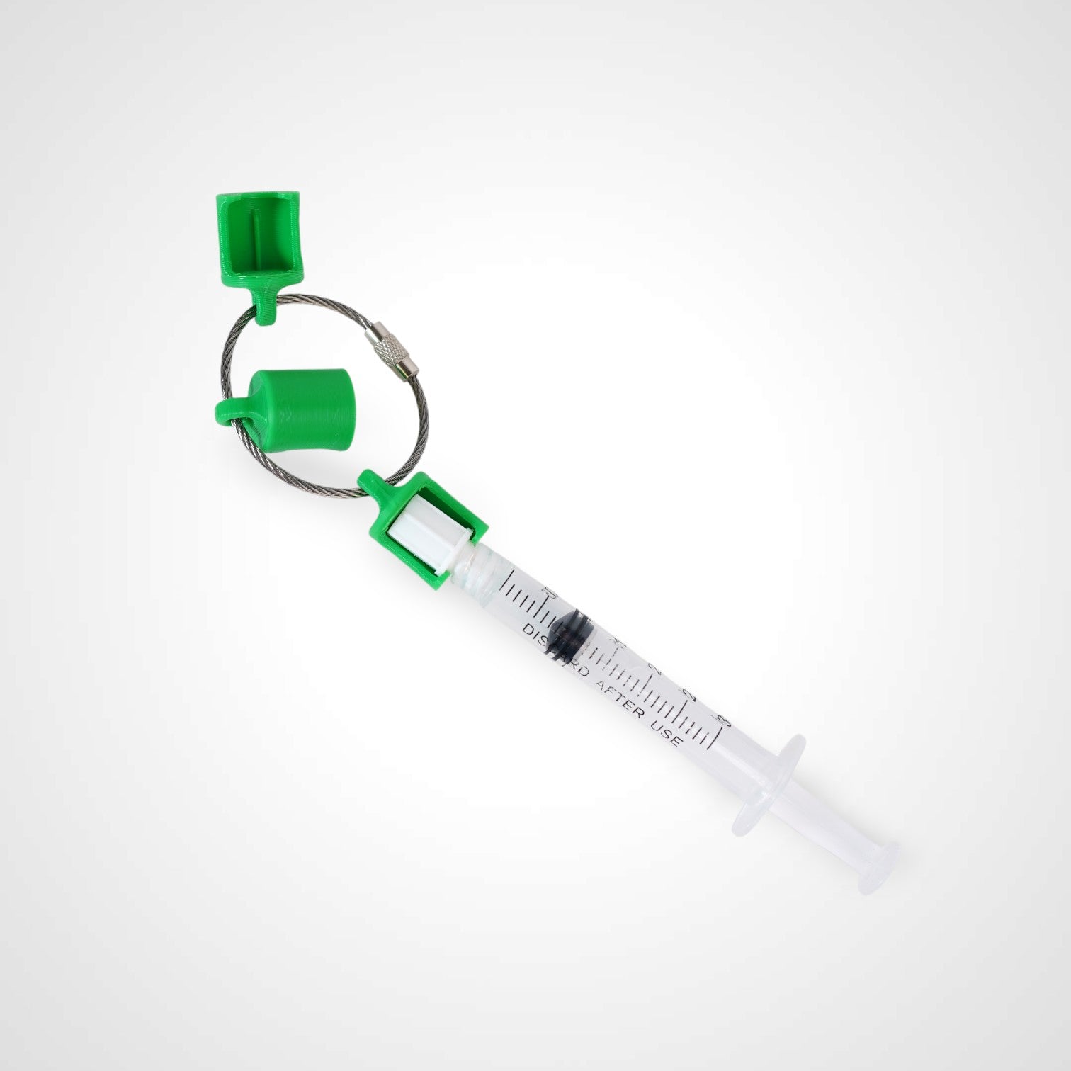 Three green polylactic acid created using additive manufacturing classic cap clips on steel cable keyring. Featured attached to a syringe. Shown on a white background.