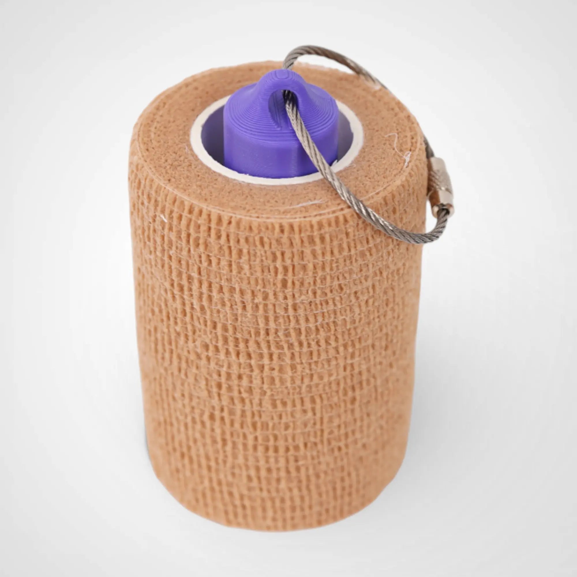 Purple 3-inch roll holder made with polylactic acid, created using additive manufacturing for holding tape and bandage rolls. With a steel cable keyring. Shown with tape on white background.