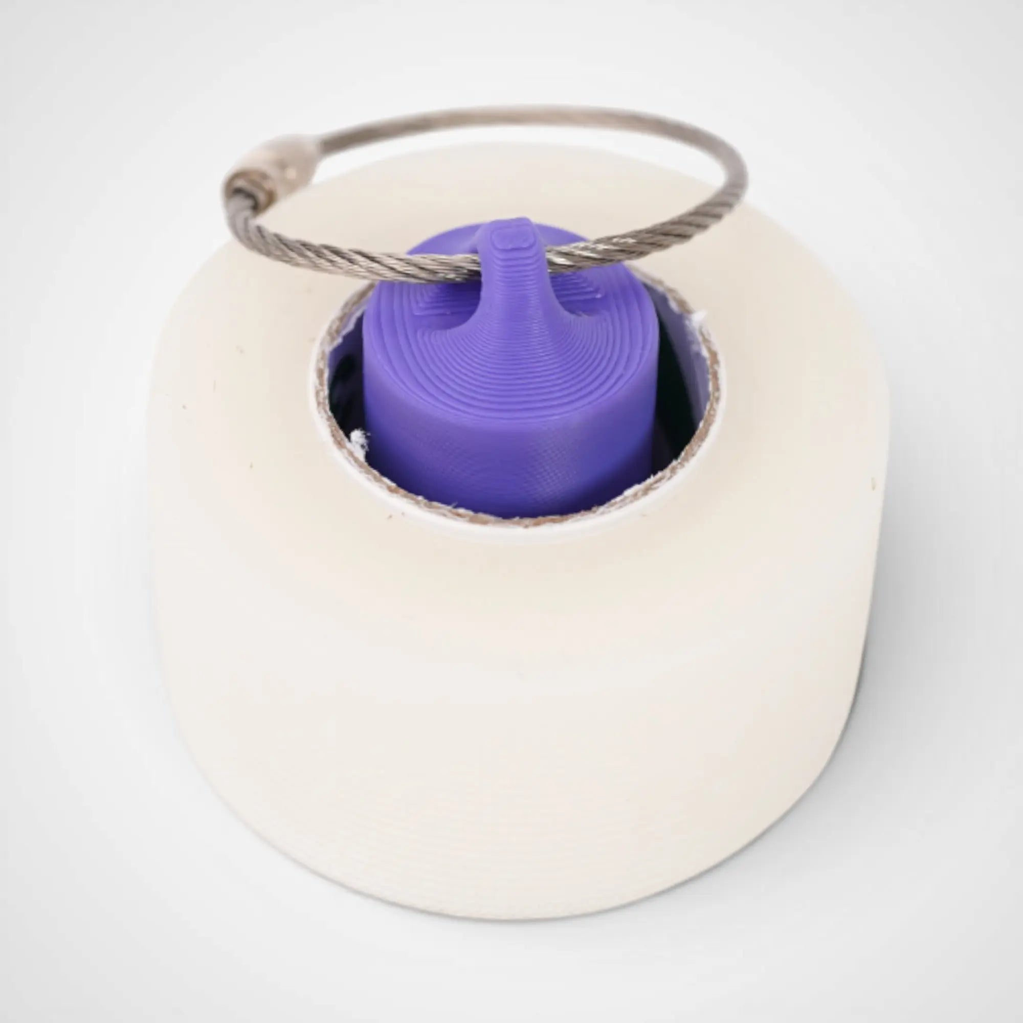 Purple 1-inch roll holder made with polylactic acid, created using additive manufacturing for holding tape and bandage rolls. With a steel cable keyring. Shown with tape on white background.