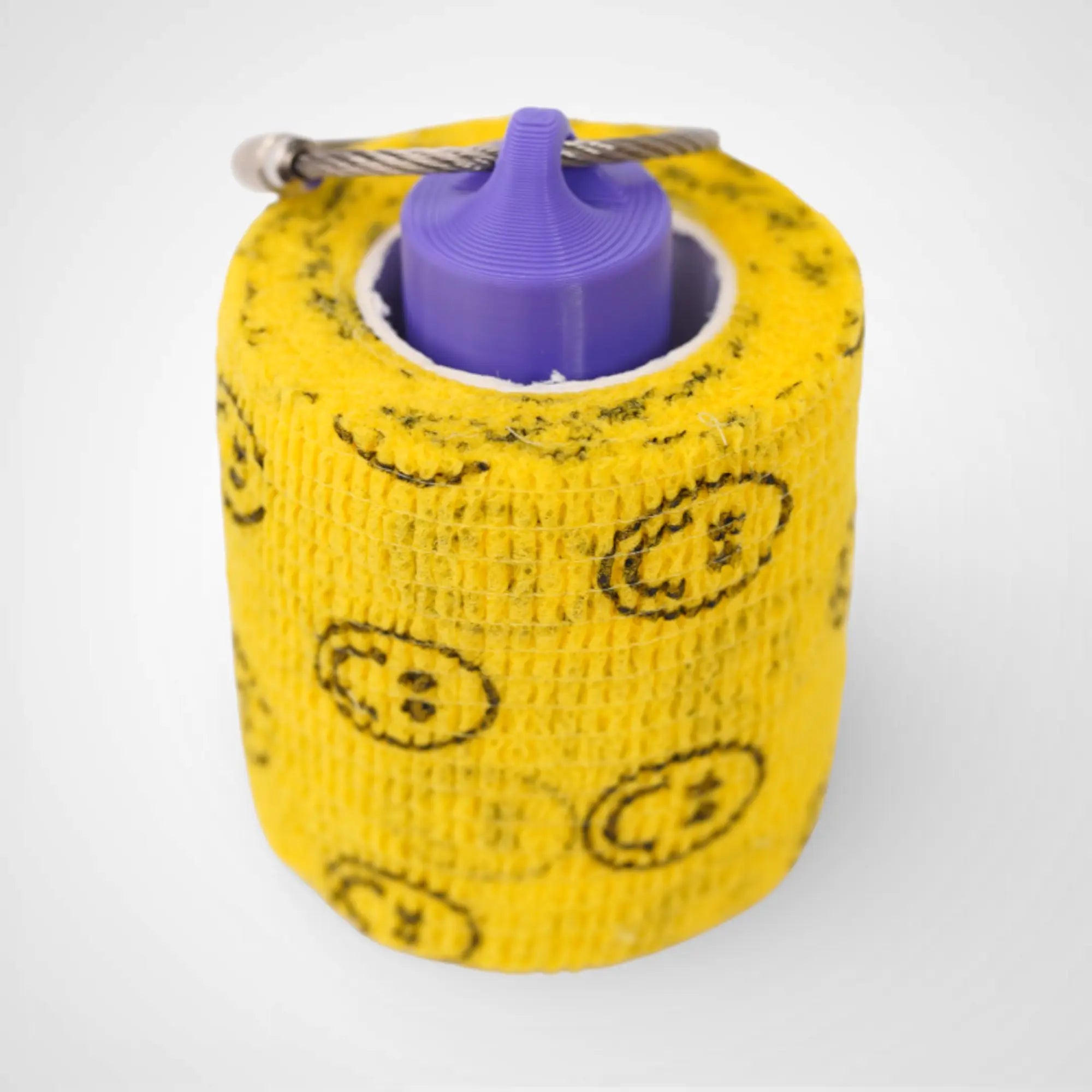 Purple 2-inch roll holder made with polylactic acid, created using additive manufacturing for holding tape and bandage rolls. With a steel cable keyring. Shown with tape on white background.