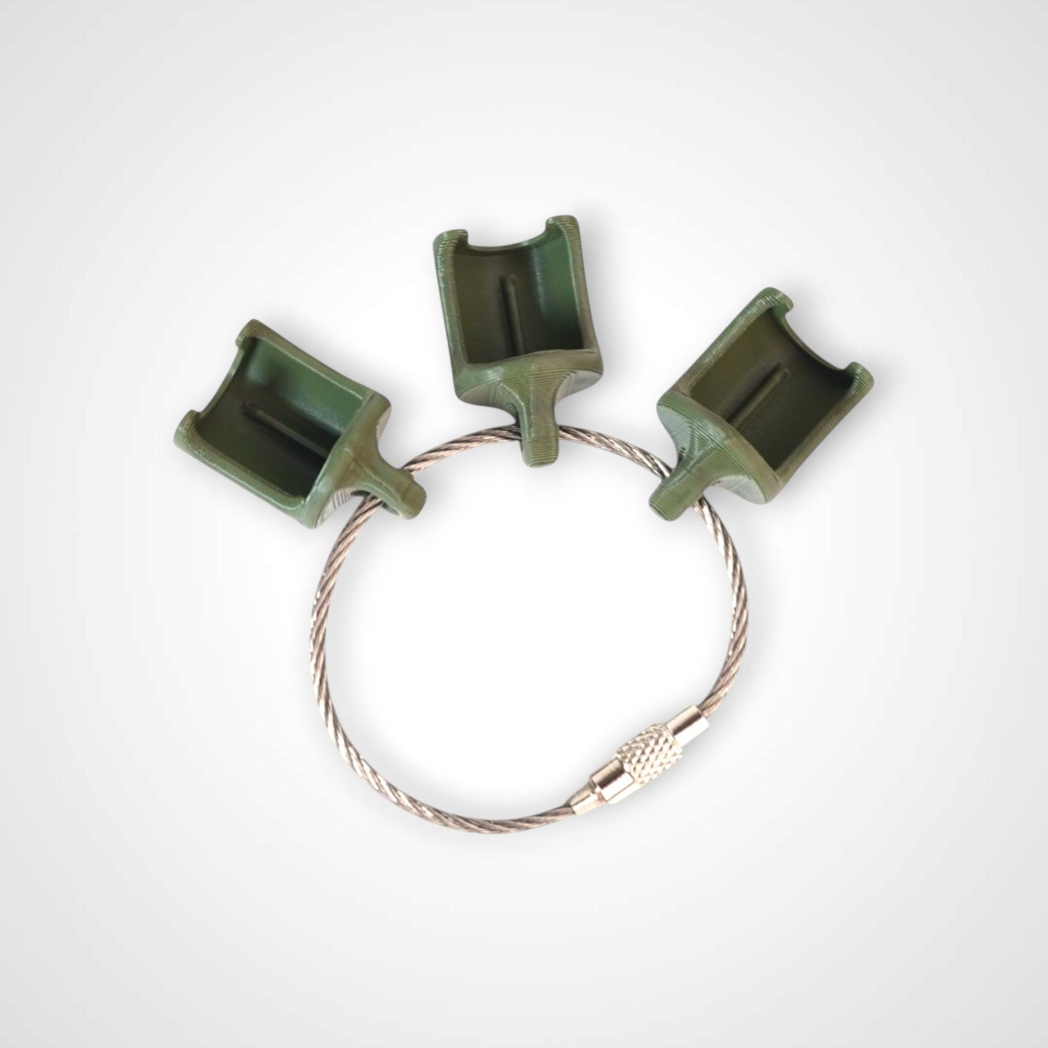 Three army green polylactic acid created using additive manufacturing classic cap clips on steel cable keyring. Shown on a white background.