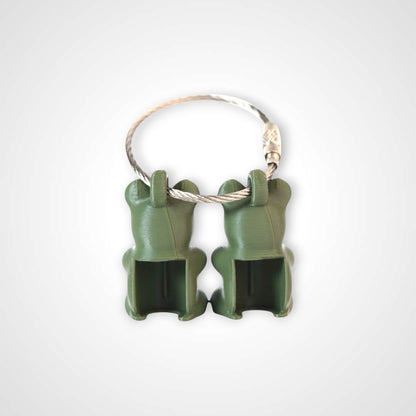 Two army green polylactic acid created using additive manufacturing gummy bear clips on steel cable keyring. Shown on a white background.