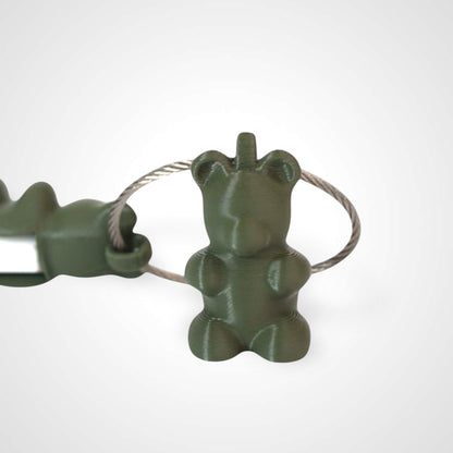 Two army green polylactic acid created using additive manufacturing gummy bear clips on steel cable keyring. Featured attached to a syringe. Shown on a white background.