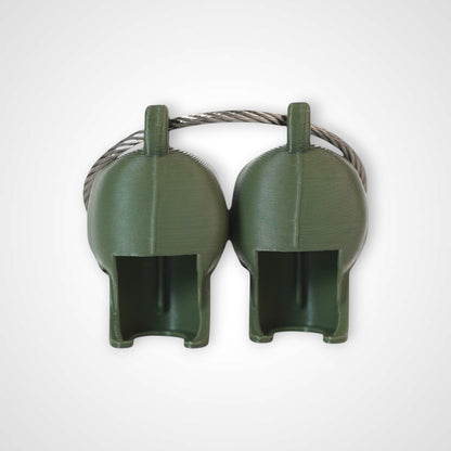 Two army green polylactic acid created using additive manufacturing skull cap clips on steel cable keyring. Shown on a white background.